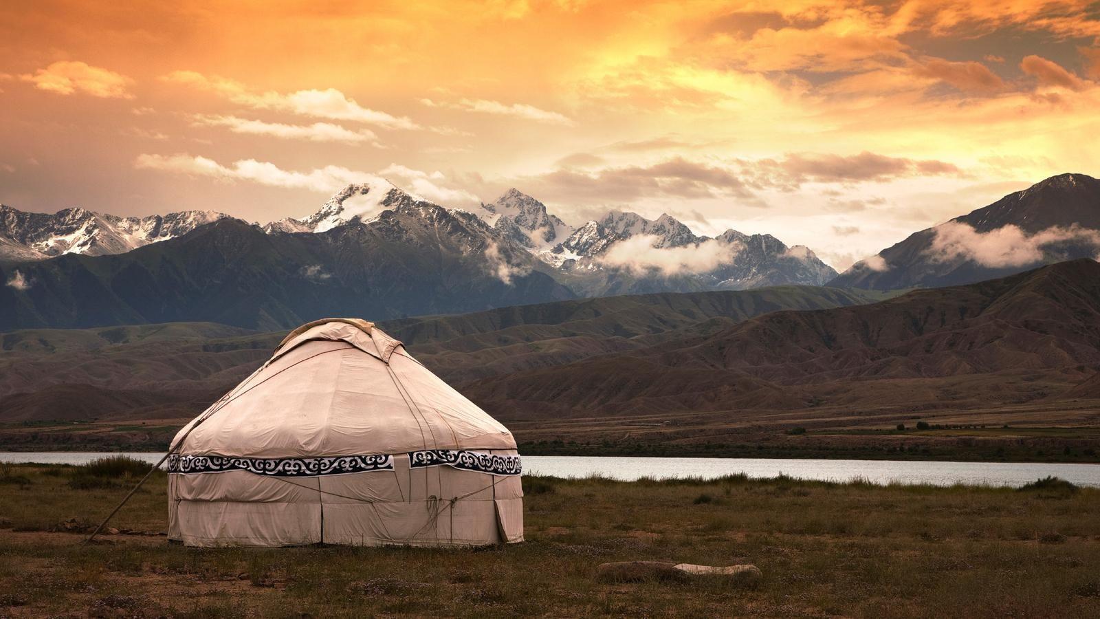 Mongolian yurt among a grassy and rocky landscape in Mongolia