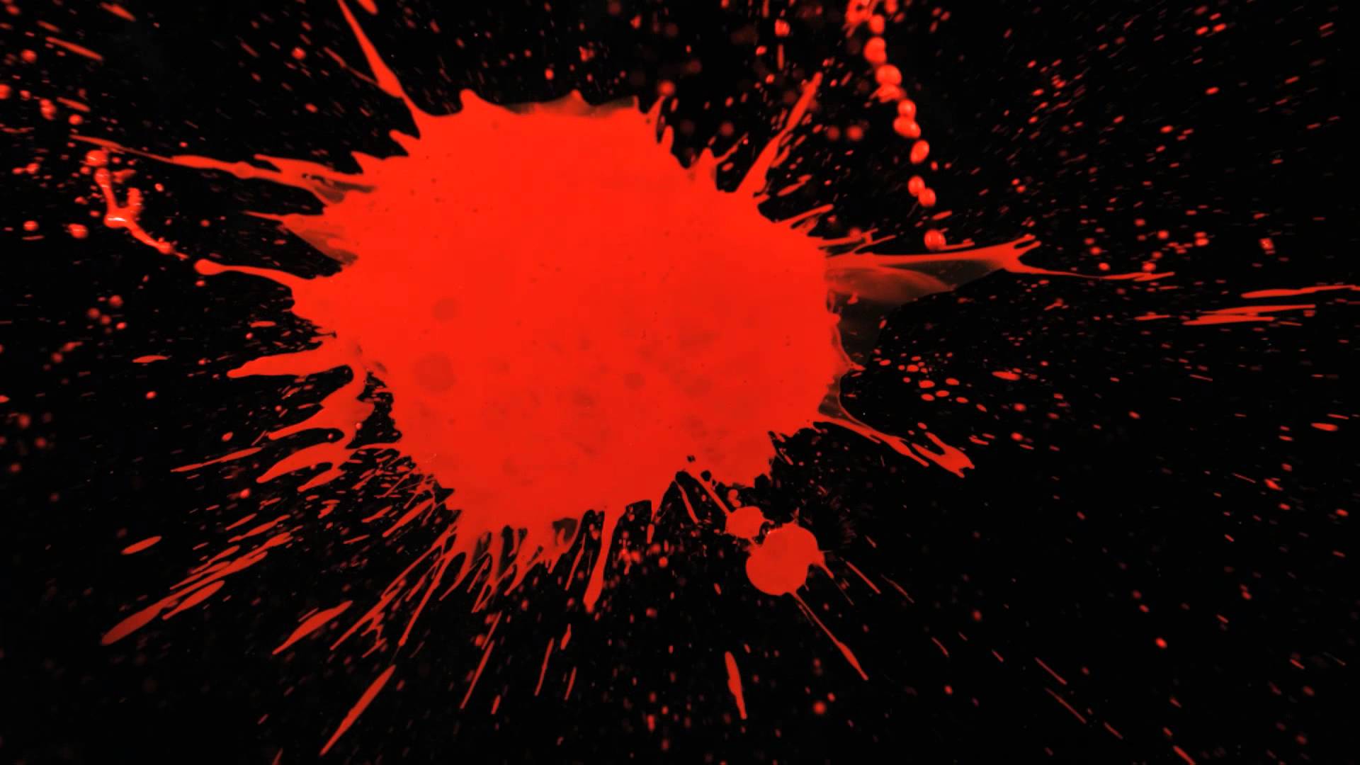 Slow Motion Paint Splatter with Red Paint Splattering a Black