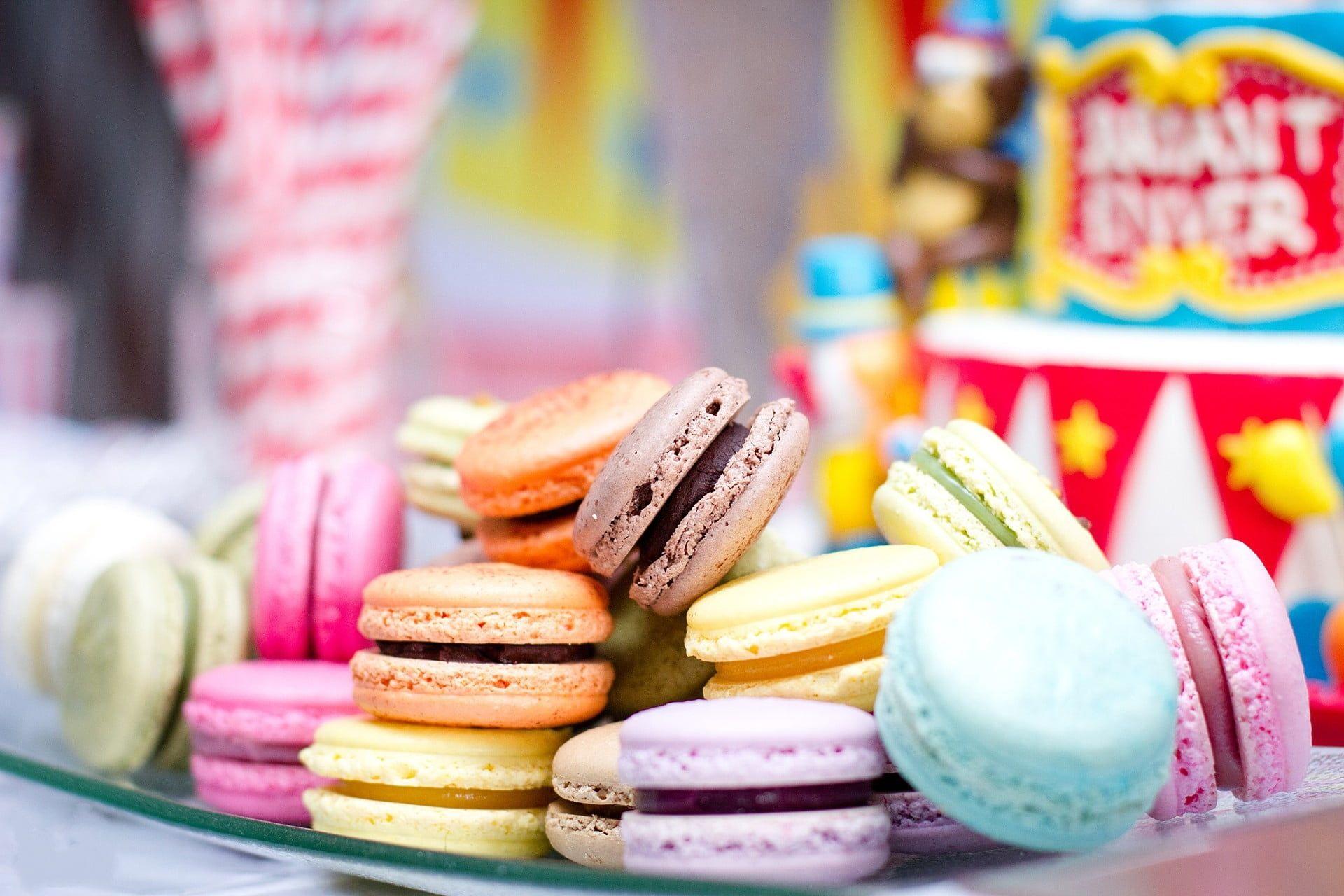 Five assorted colors macaroons on white ceramic plate during daytime