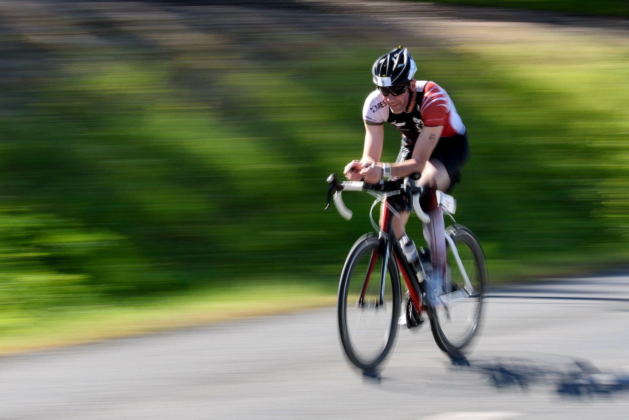 Man on road bike beside green grass at dyatime HD wallpaper