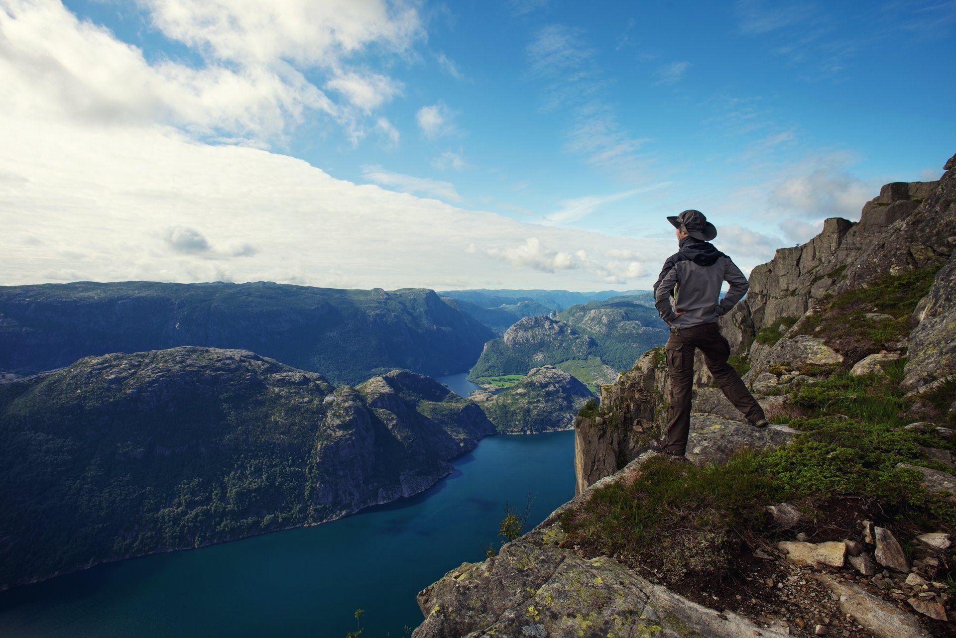 lonely guy man traveler hiker fjord panorama sea sky mountain clouds