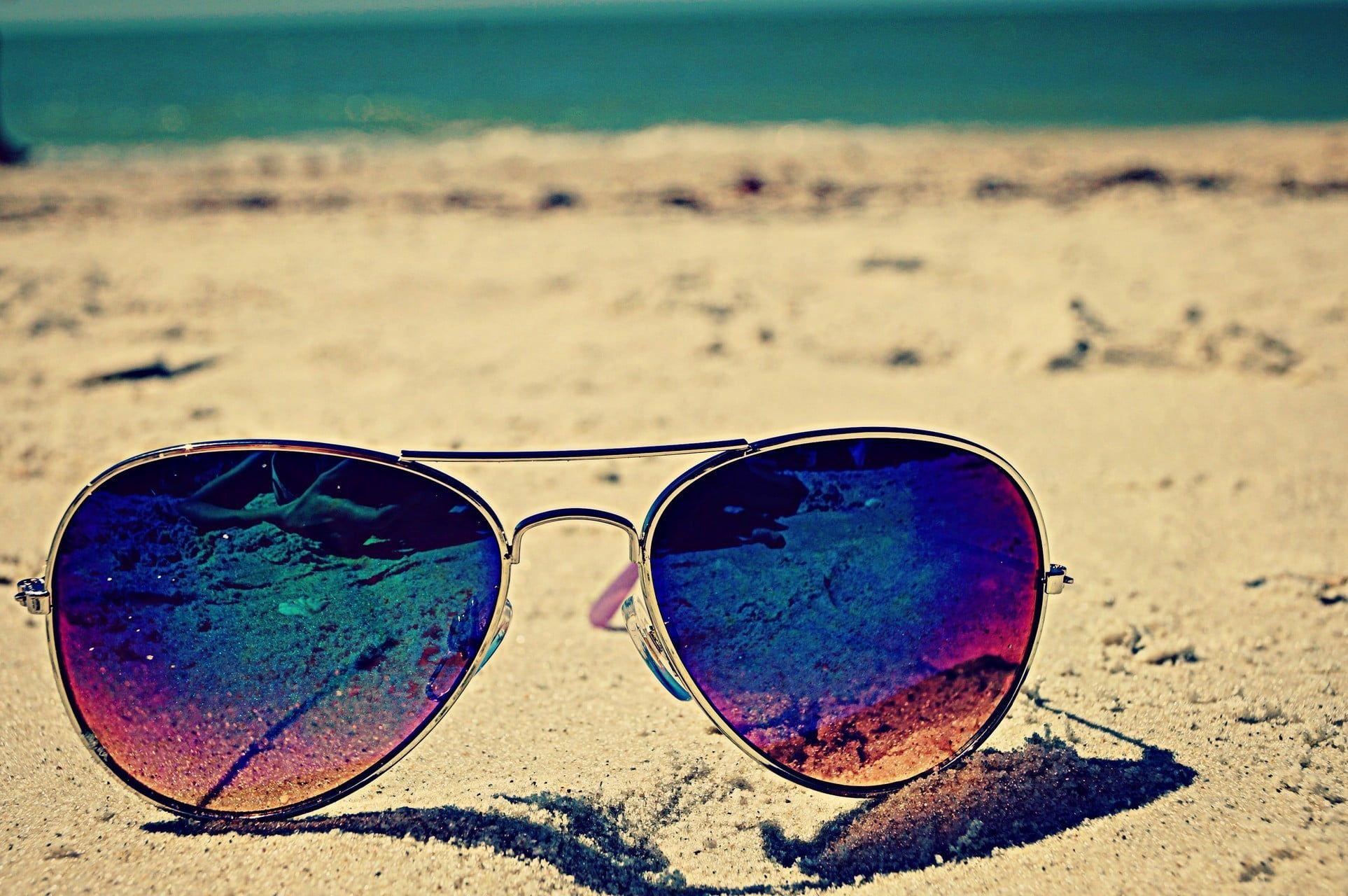 Gold Colored Framed Aviator Style Sunglasses On Beach Sand HD