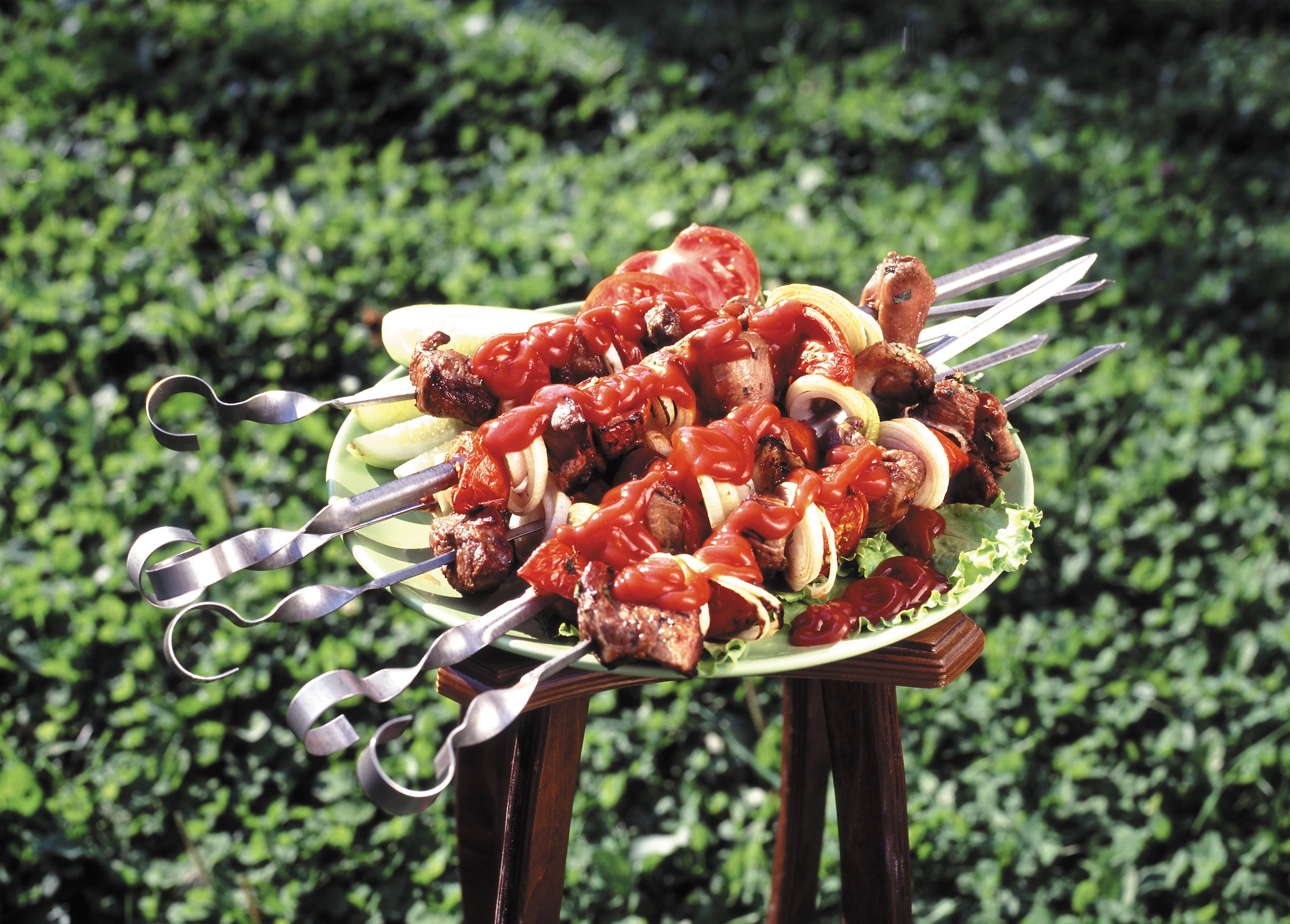 Depth of field of skewers on green vegetable leaf and white plate