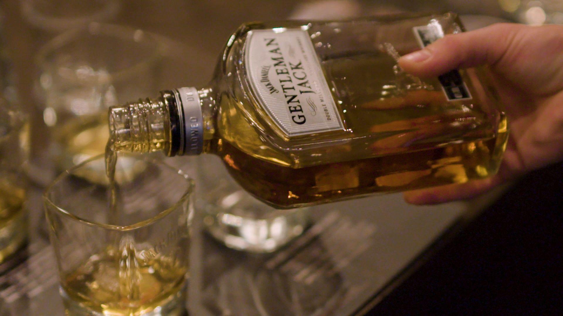 Drinks at a bar. Pouring Jack Daniel's whiskey in glasses Footage