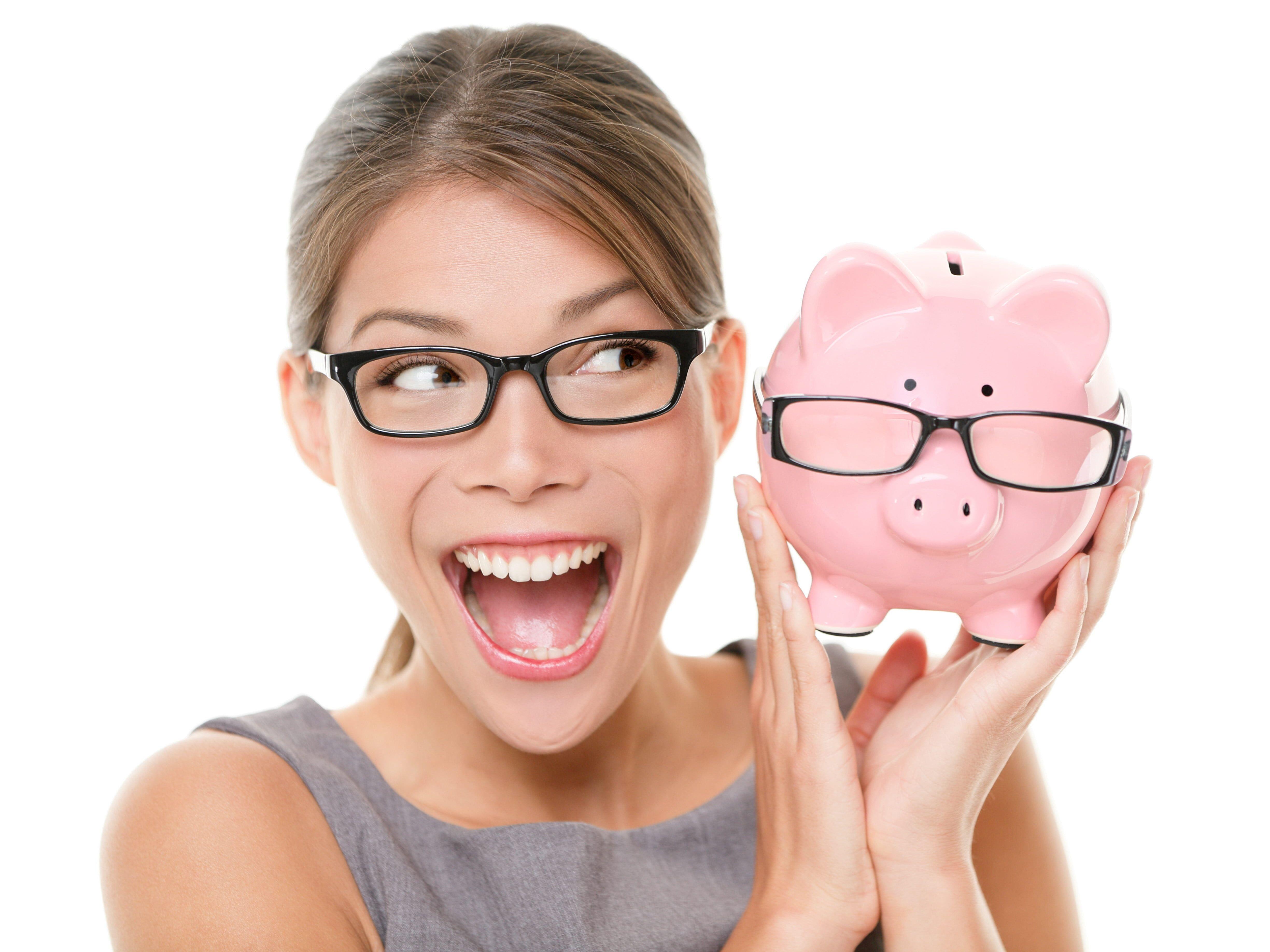 Woman wearing black framed eyeglasses holding pink piggy bank HD