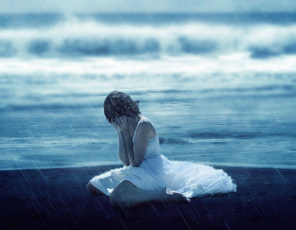 Lonely girl crying with tears in rain thinking of forgotten love