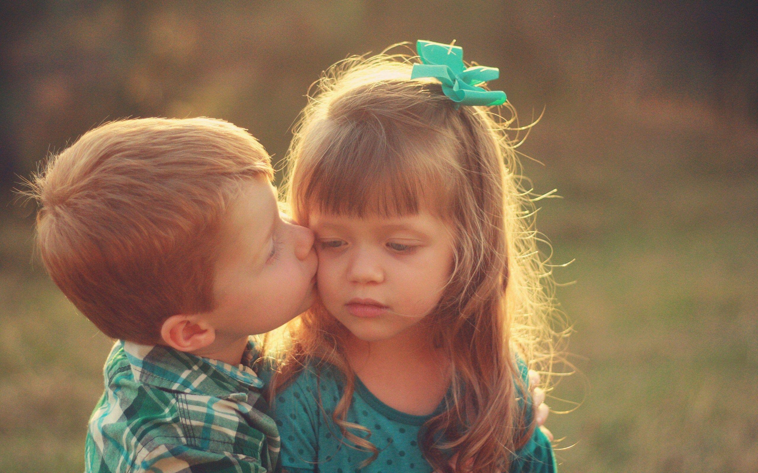 小男孩亲吻正在玩积木的女孩。照片摄影图片_ID:151479871-Veer图库