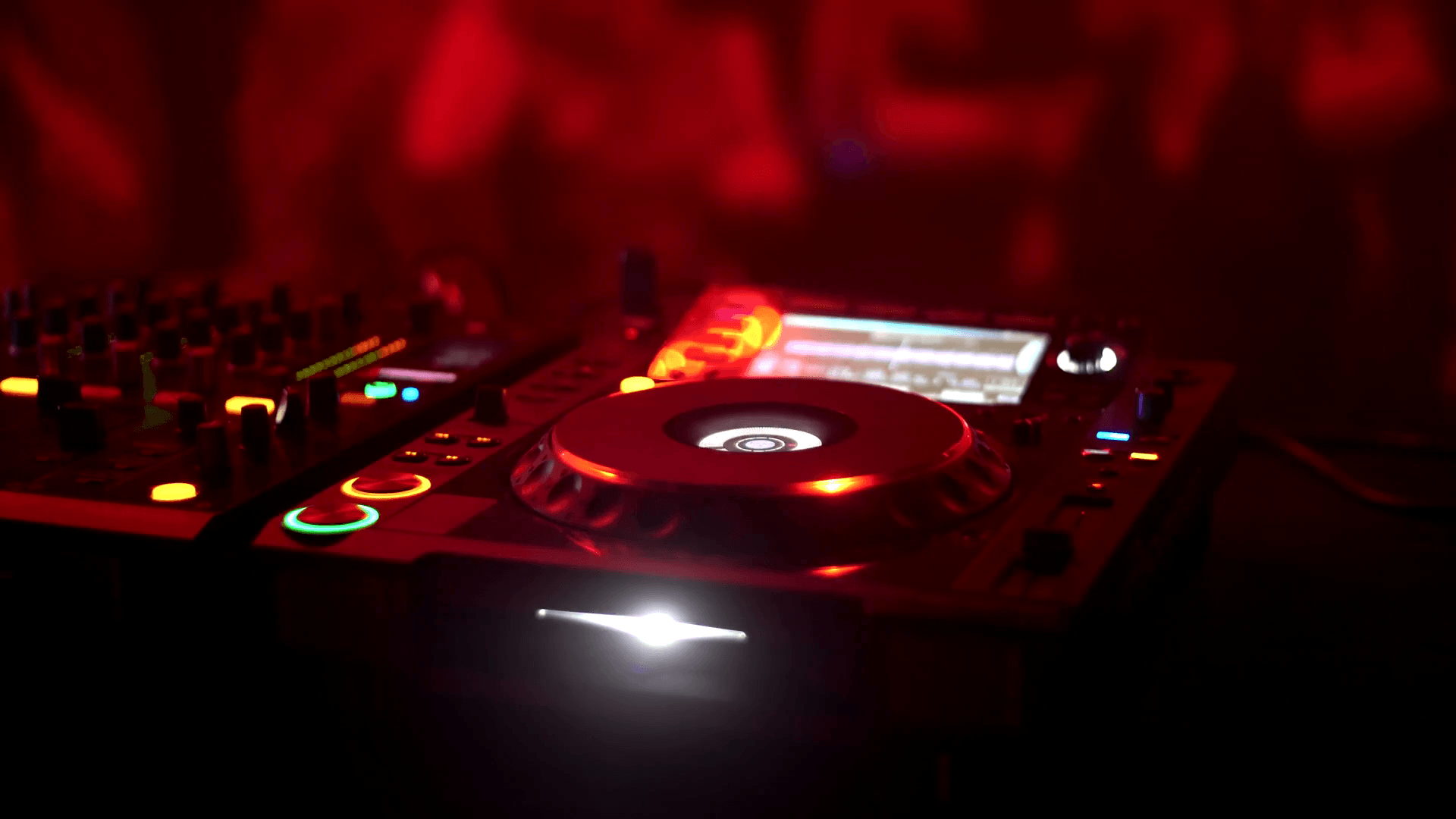 DJ disk jockey mixing songs at his desk turntable in a nightclub