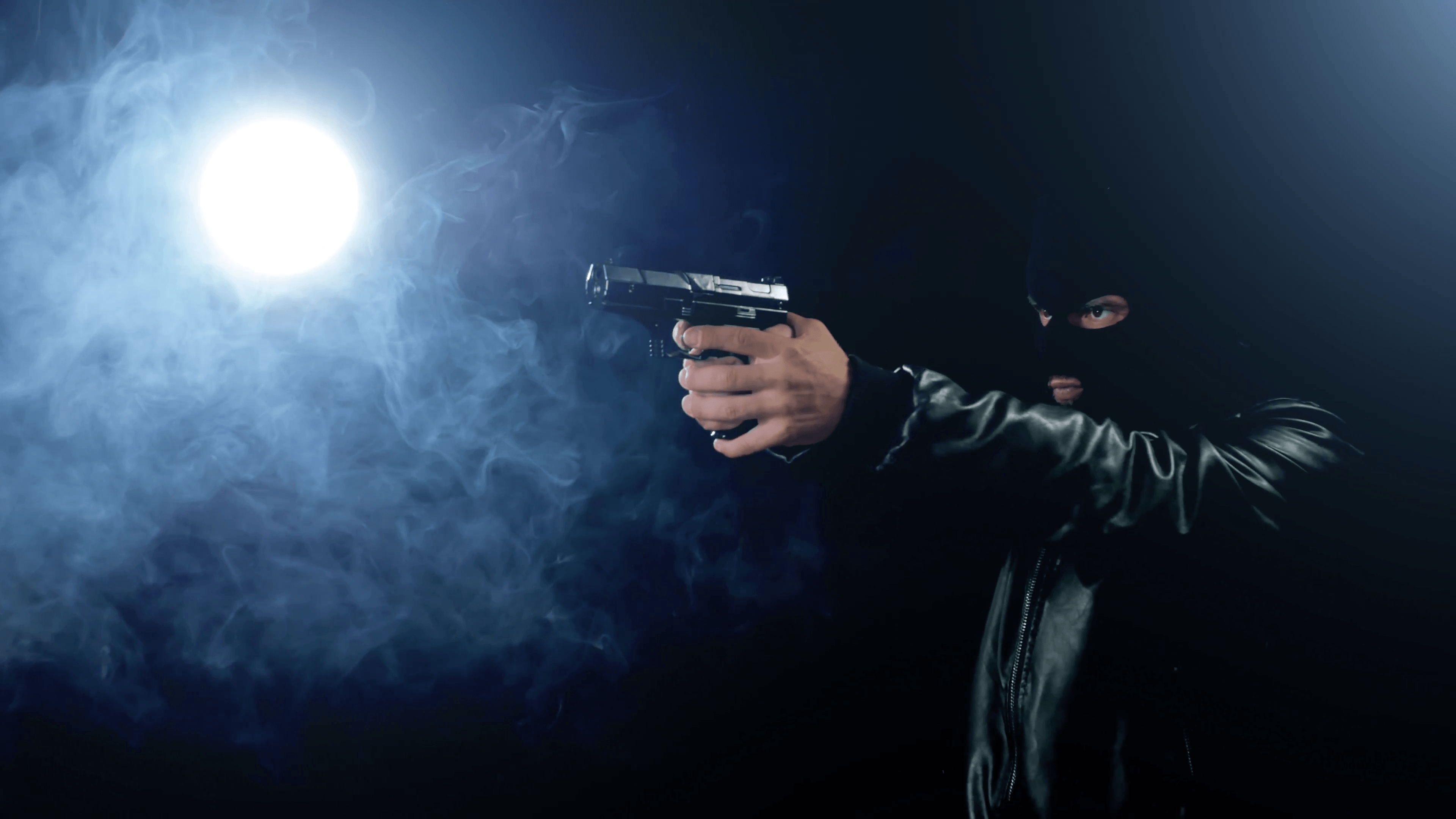 masked criminal gangster holding gun black background Stock Video