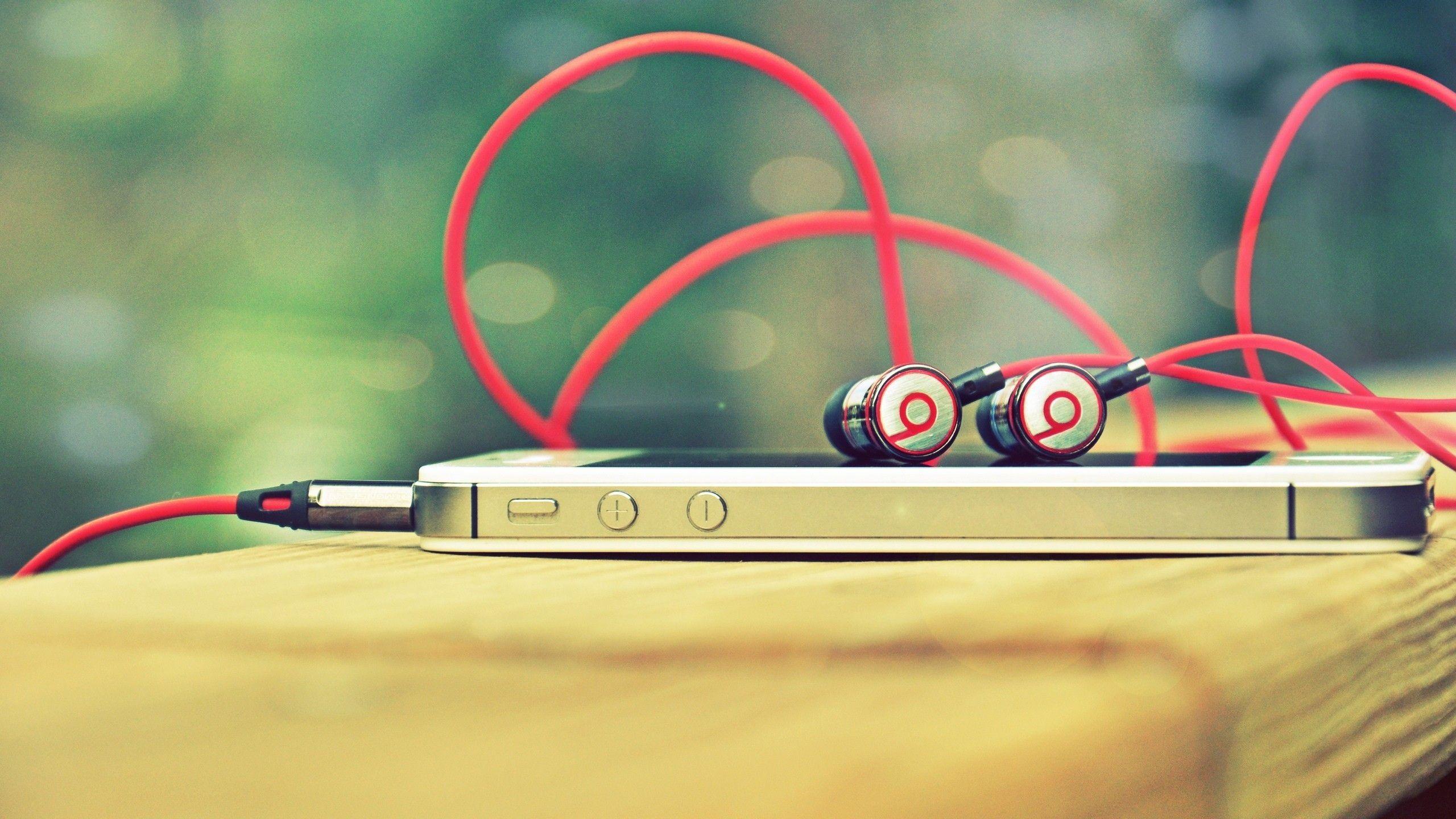 Black and red Beats earphone and white iPhone 4S HD wallpaper