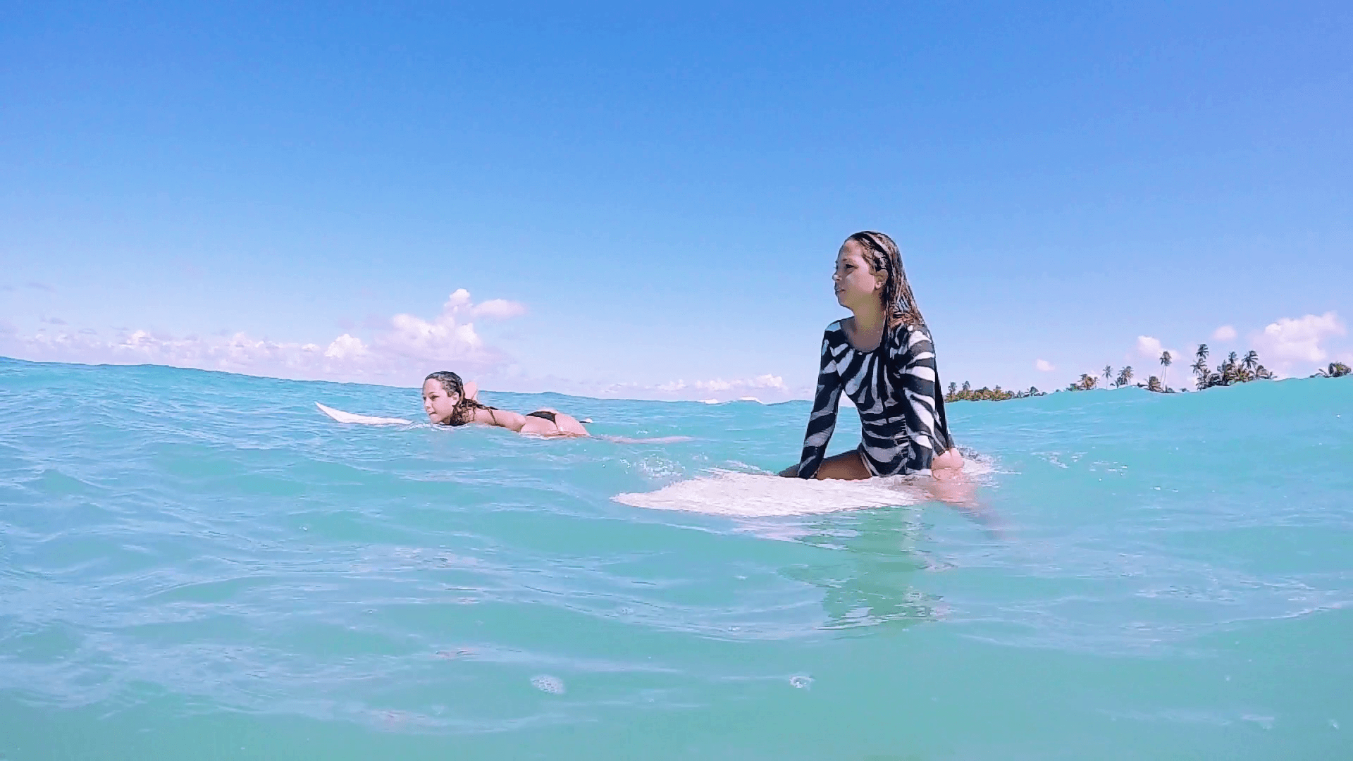 Active Surf Girls Sitting On Surfboard In The Ocean In Slow Motion