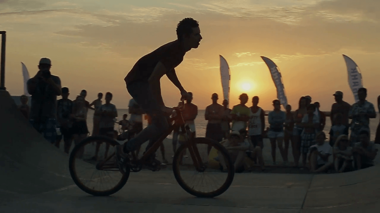 Athletes Making Jumps And Tricks on a Bike on sunset background. Bmx