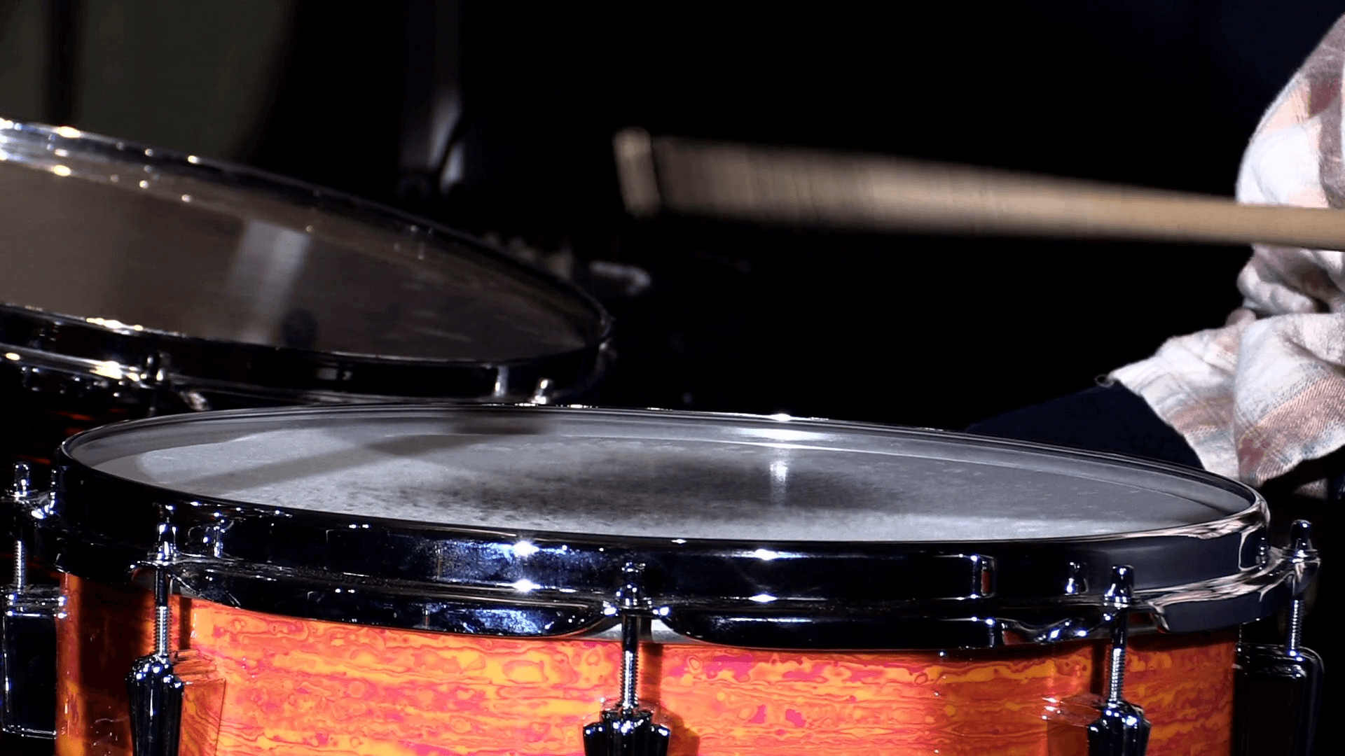 Slow motion close up shot of drums sticks hitting a snare drum