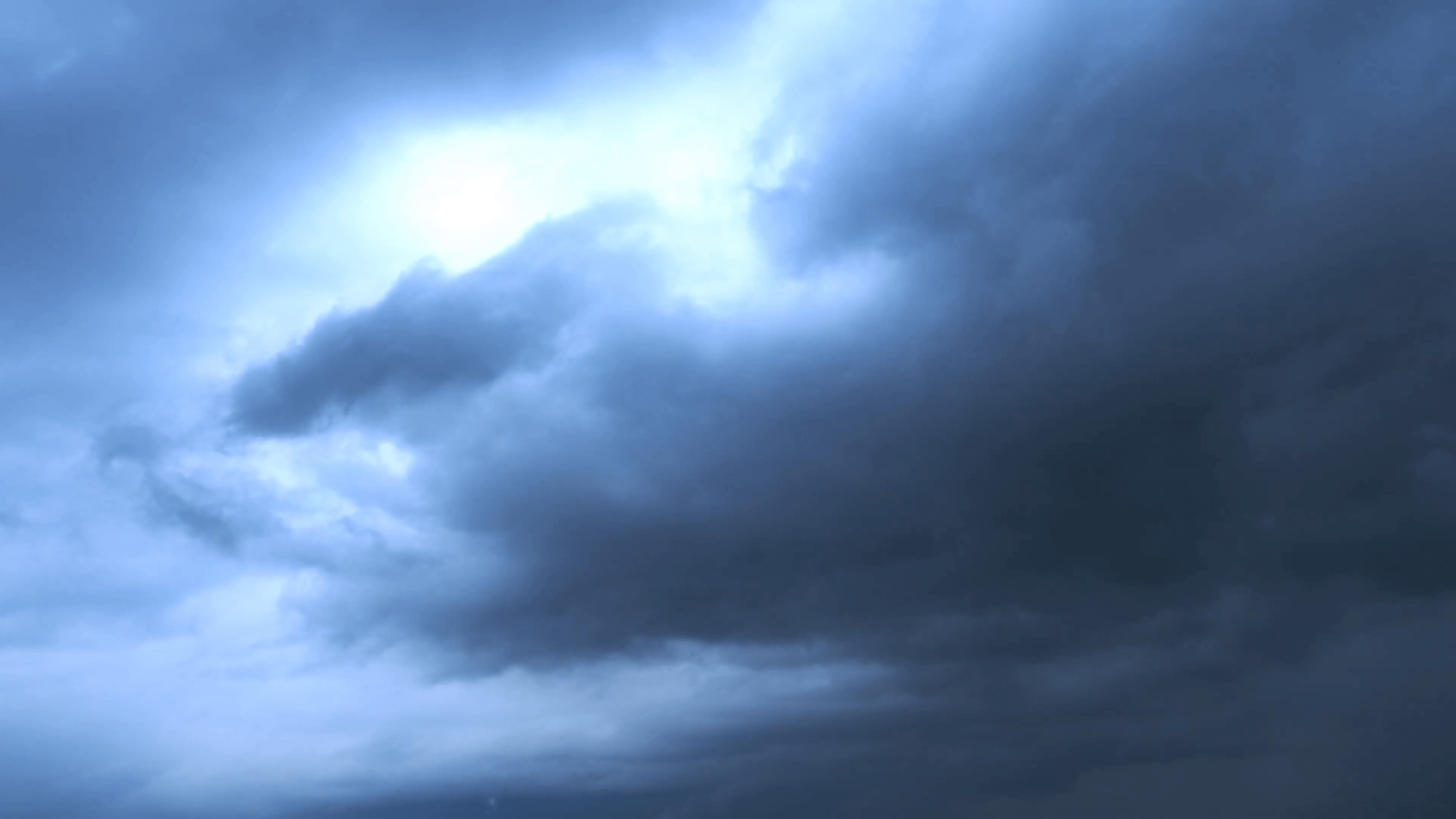 Dramatic dark blue storm clouds with bright light 4K extreme nature