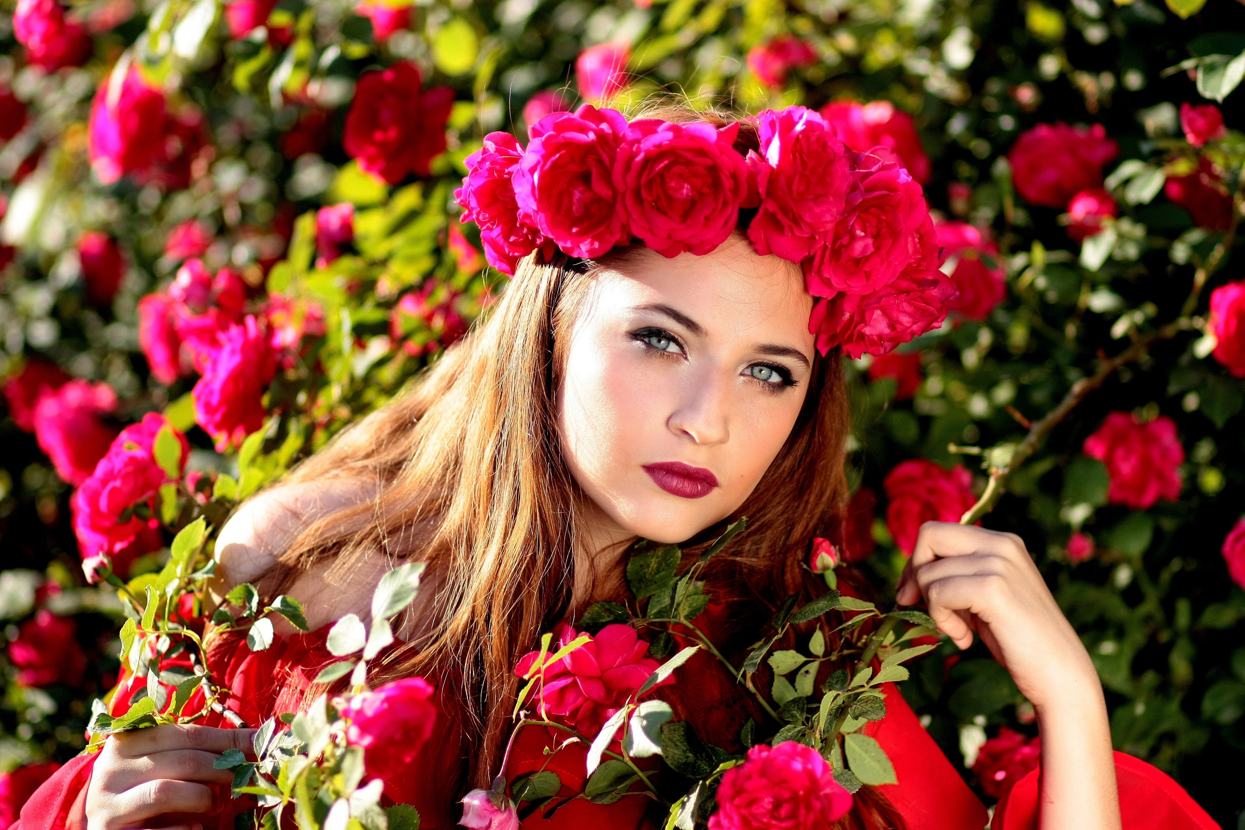Woman wearing red Rose headband posing in red Rose garden