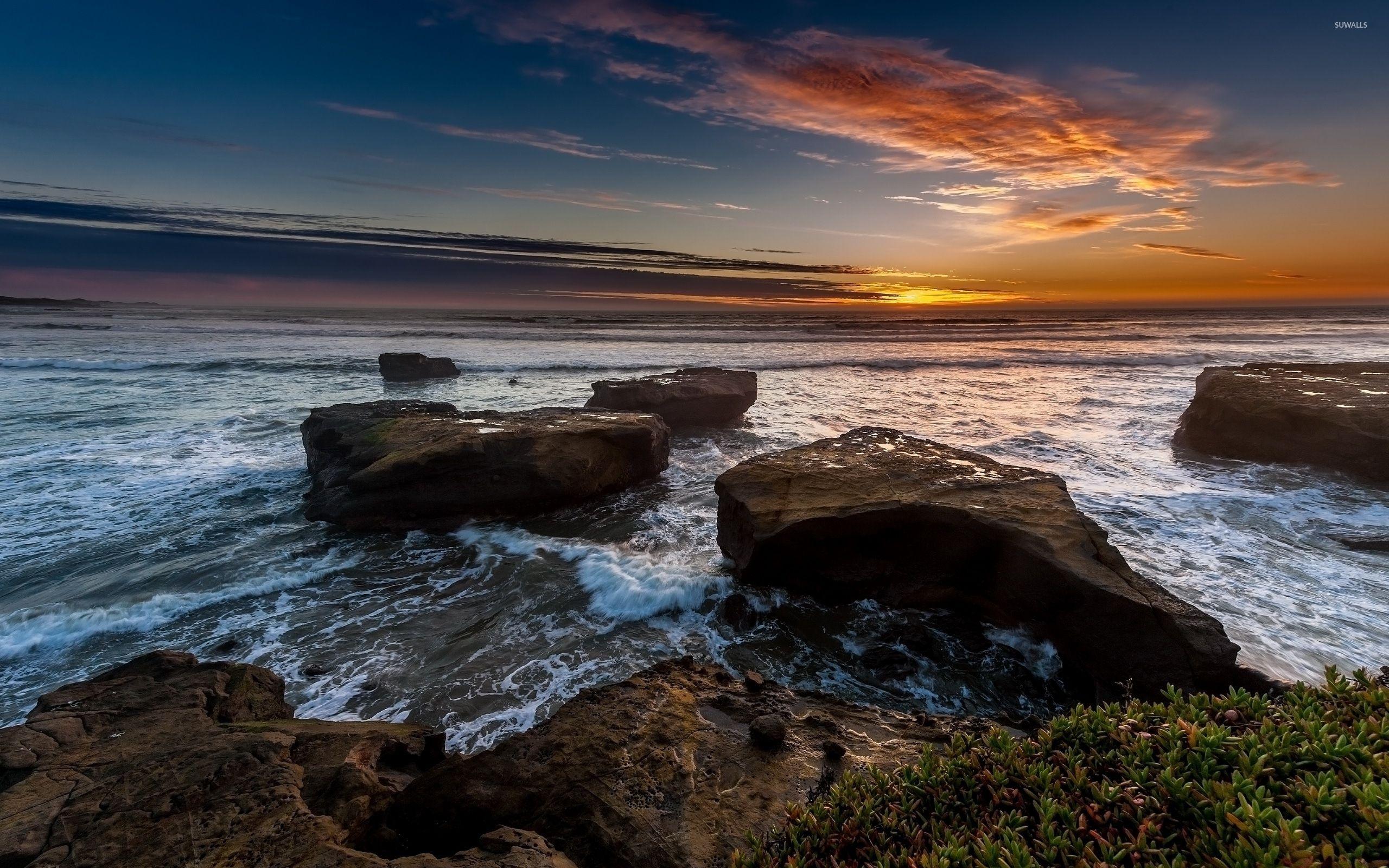Beautiful ocean sunset above the rocky shore wallpaper