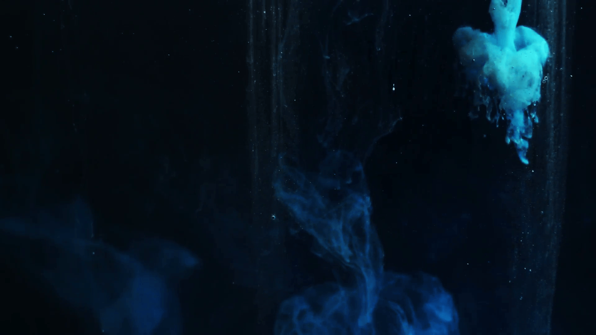 Abstract dark blue abstract background, ink in water close up. Full