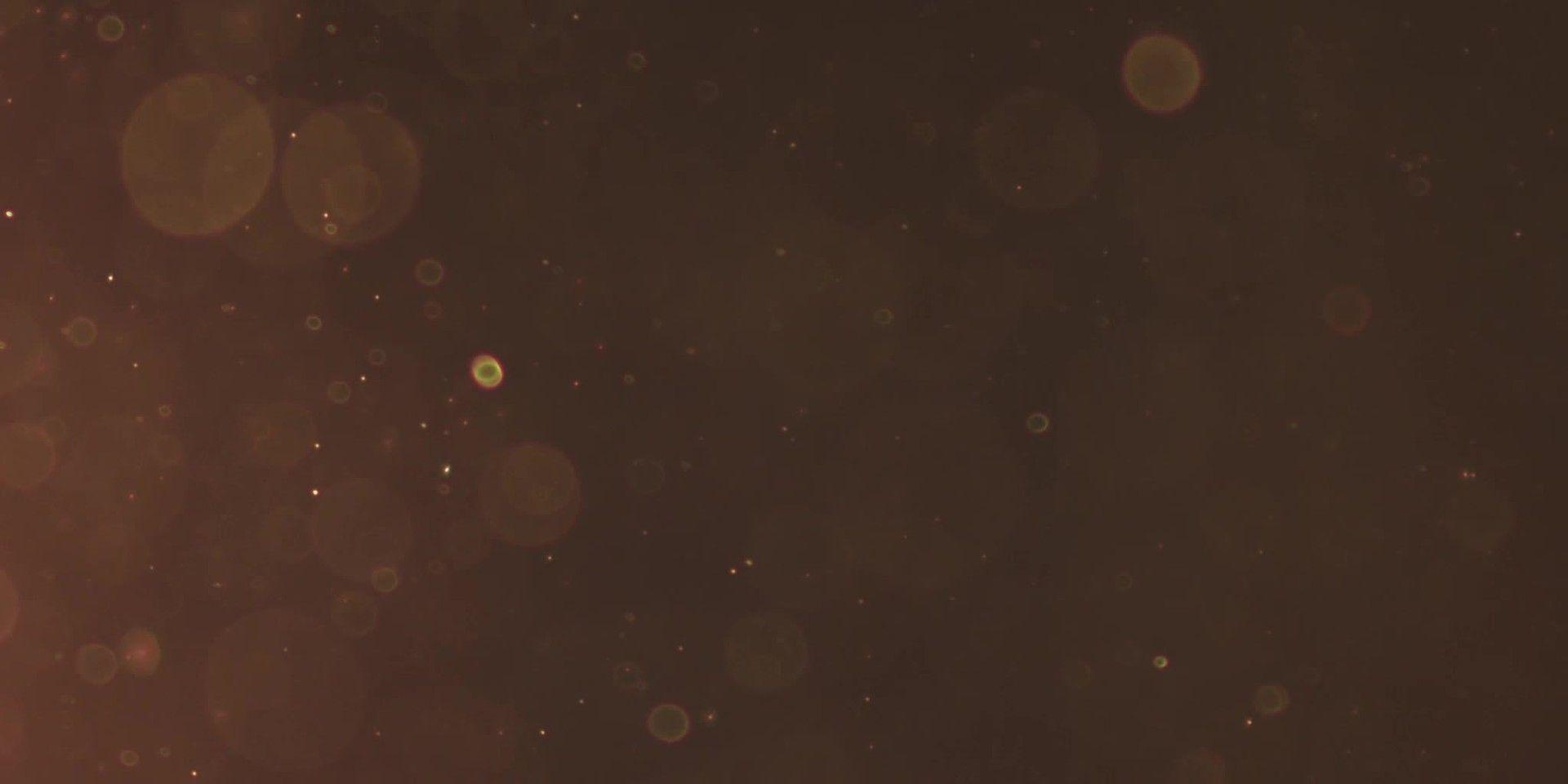 Particles of different sizes floating on sepia background