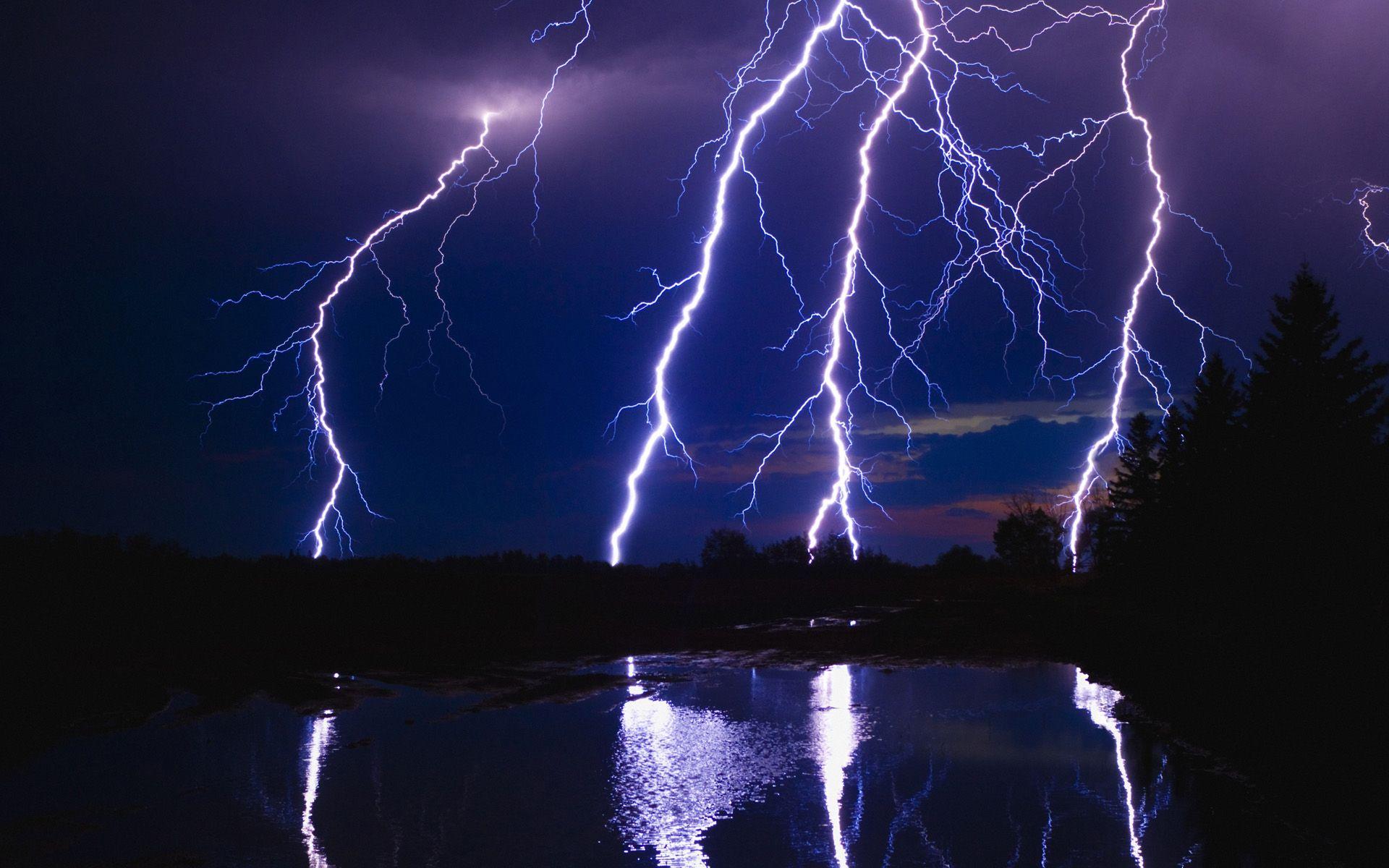 Four lightning strikes in dark blue sky