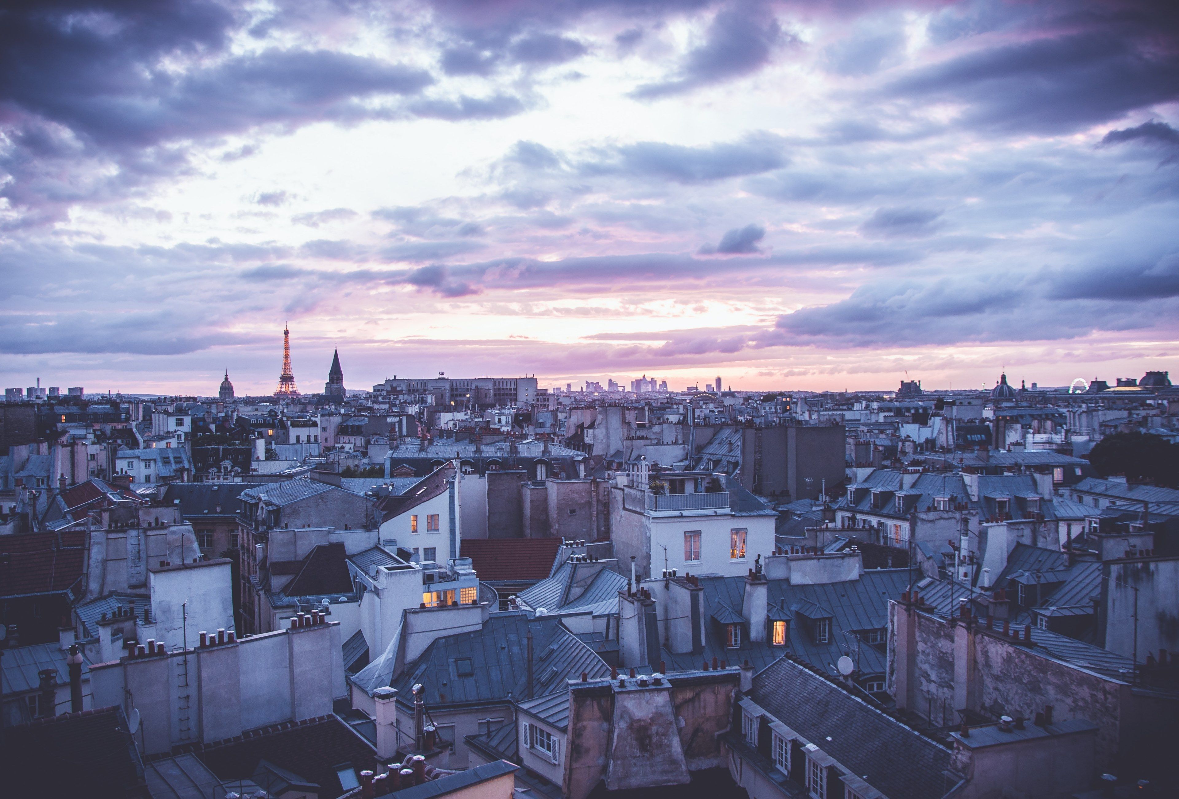 a view of the urban cityscape and clouds from a rooftop of paris