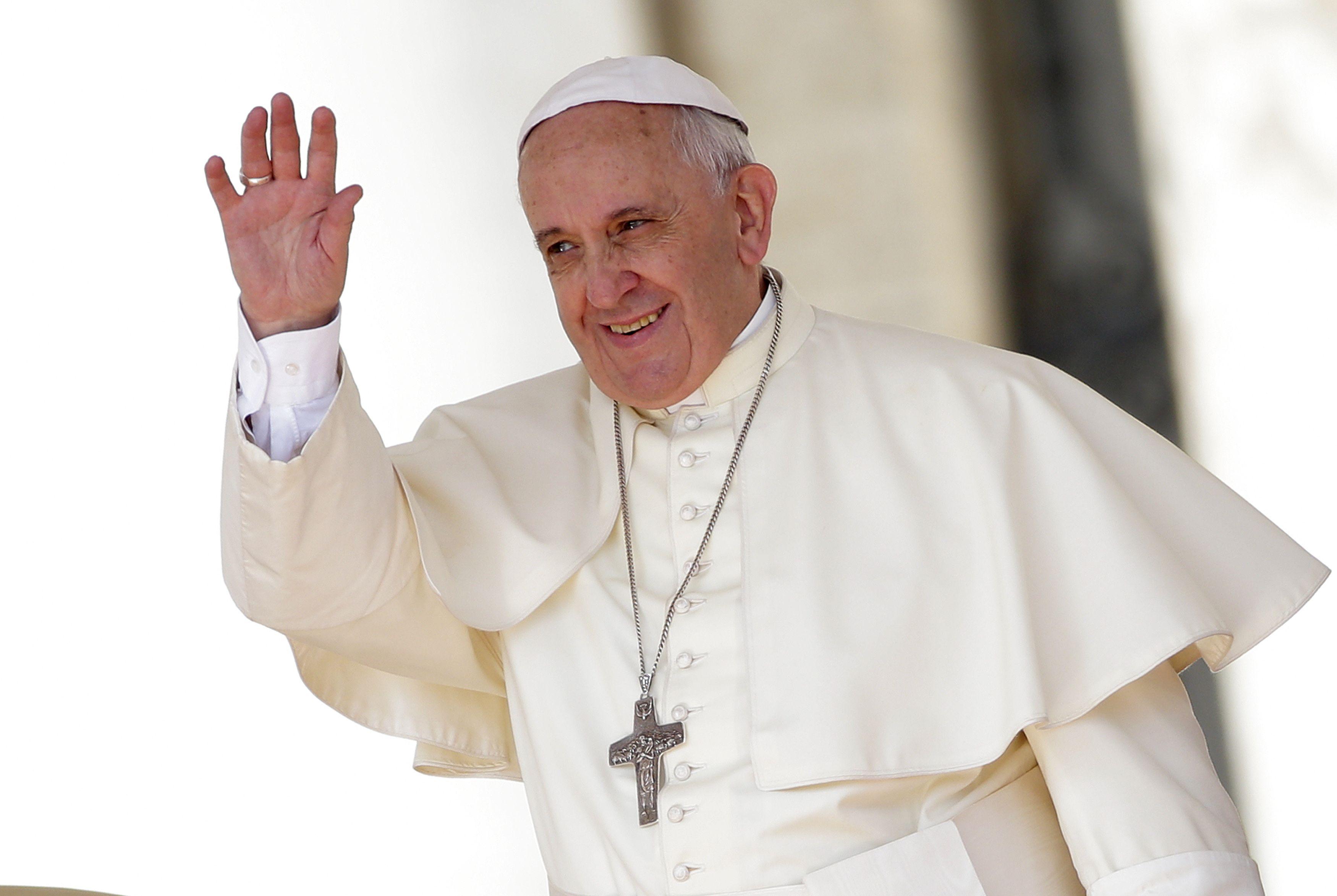 Pope Francis waves as he leads his weekly audience in Saint Peter's
