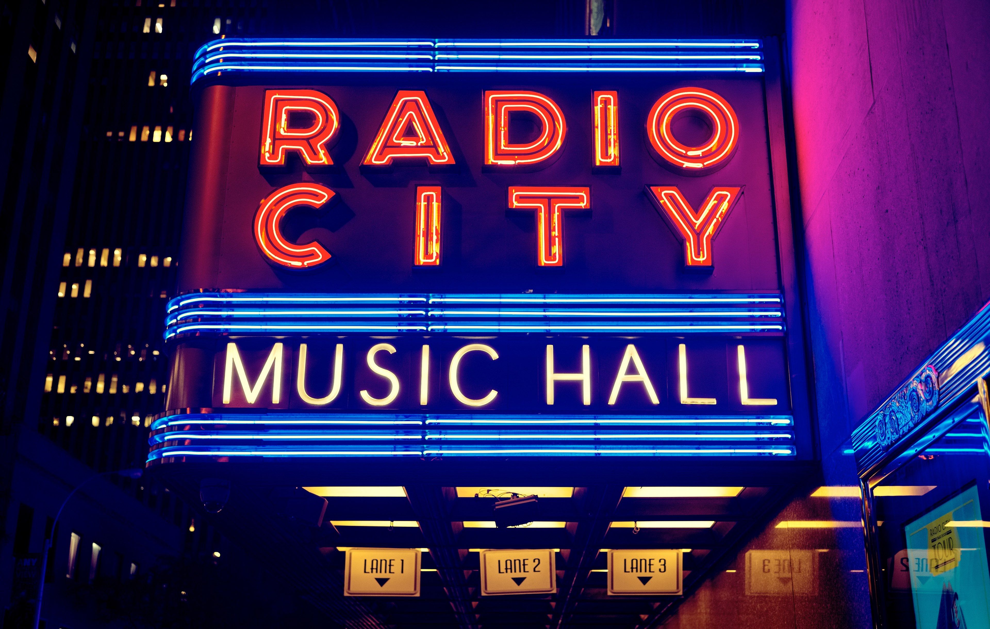 a large neon sign reads radio city music hallradio city music hall
