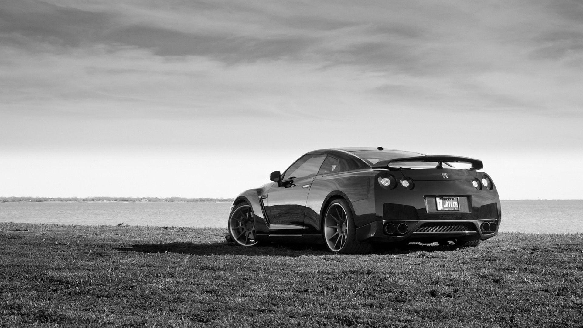 Black and white photo of a car on the beach wallpaper and image