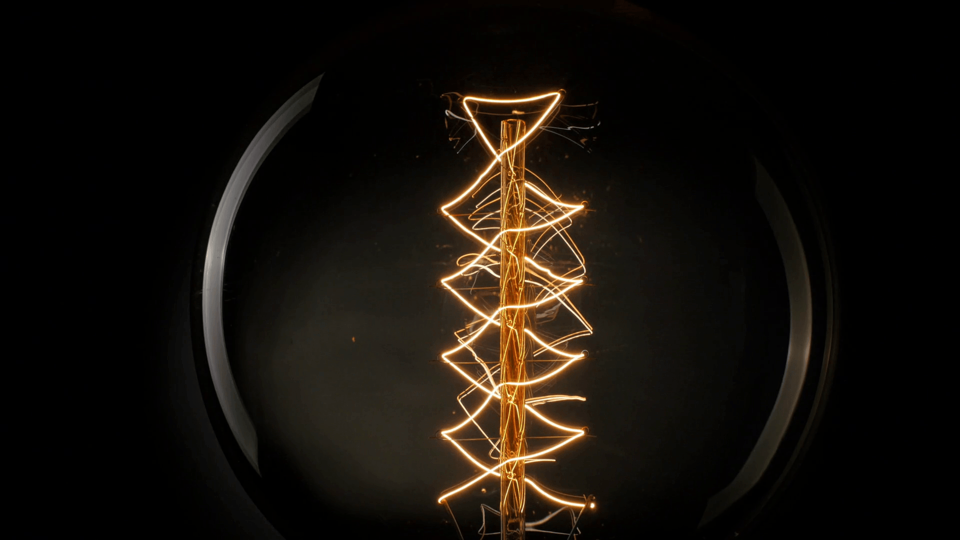 Vintage Edison light bulb on black background Stock Video Footage