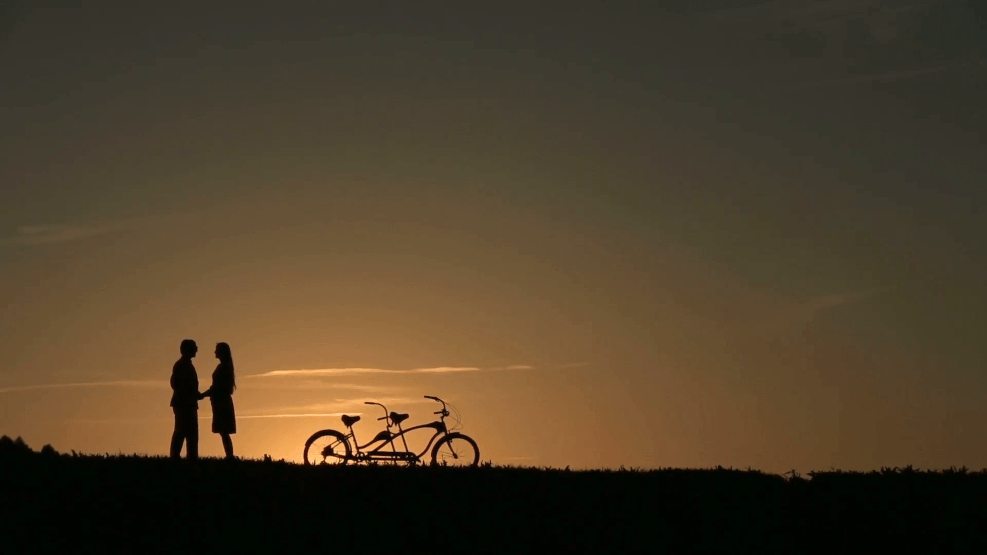 Romantic Couple with Tandem Bicycles Kissing While Sunset. Summer