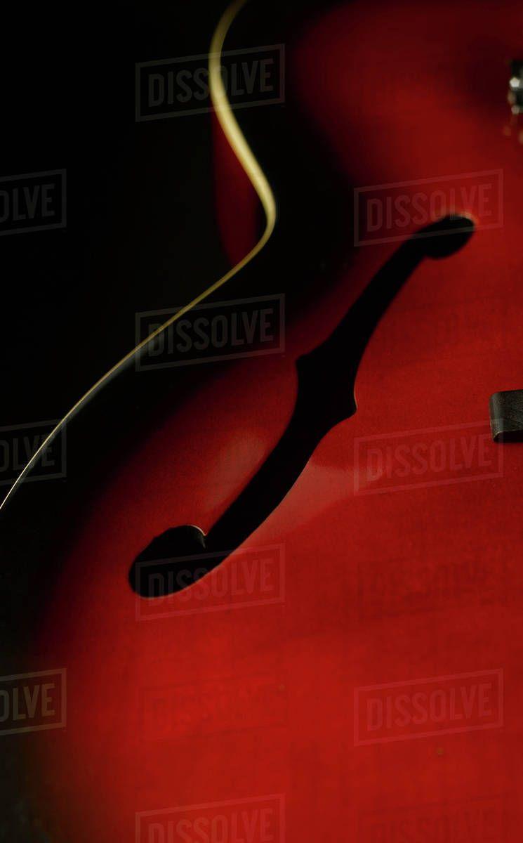 Guitar against black background, close up