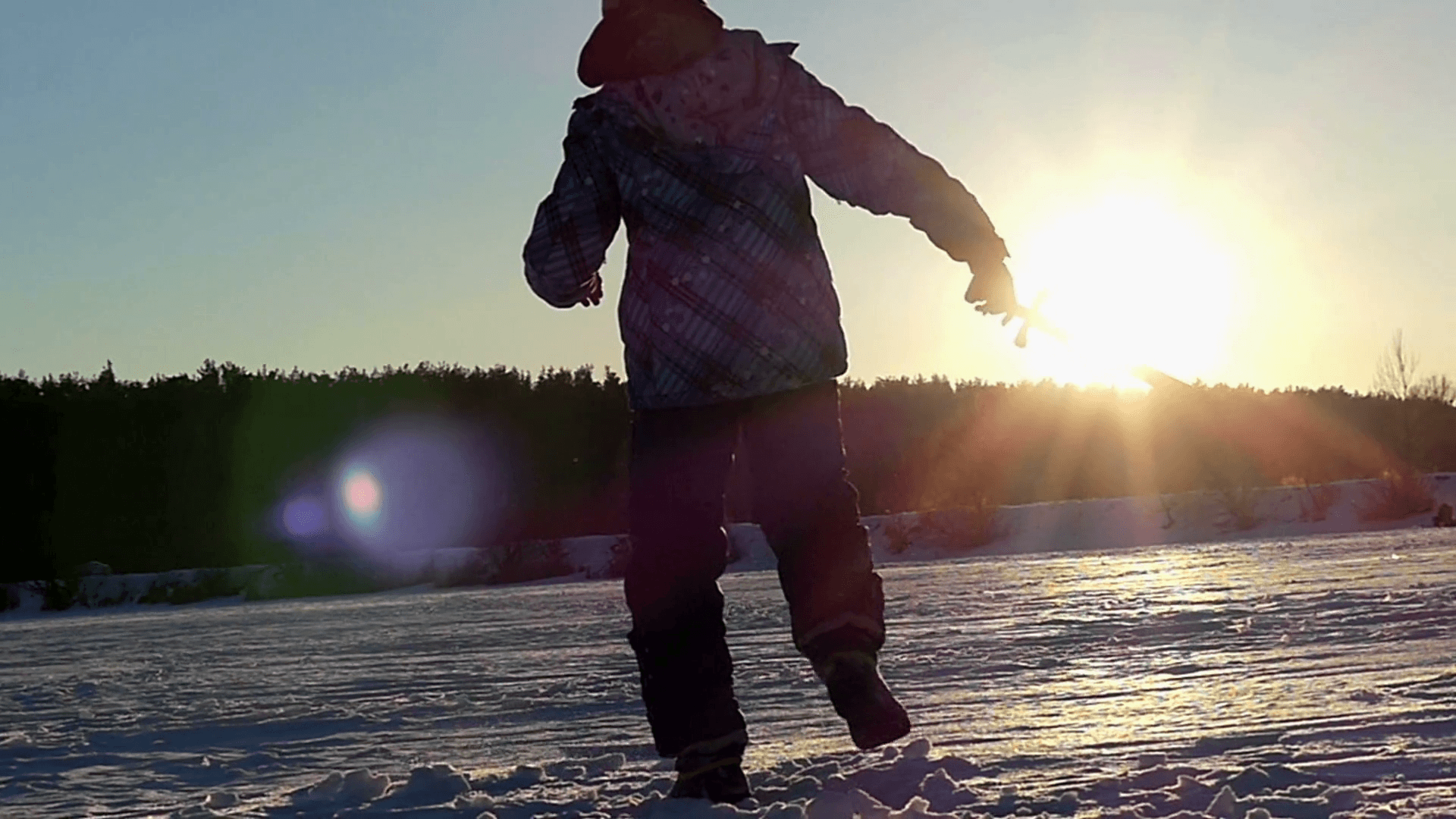 Little Boy at Winter Playing With Shadow With Wooden Sword at Sunset