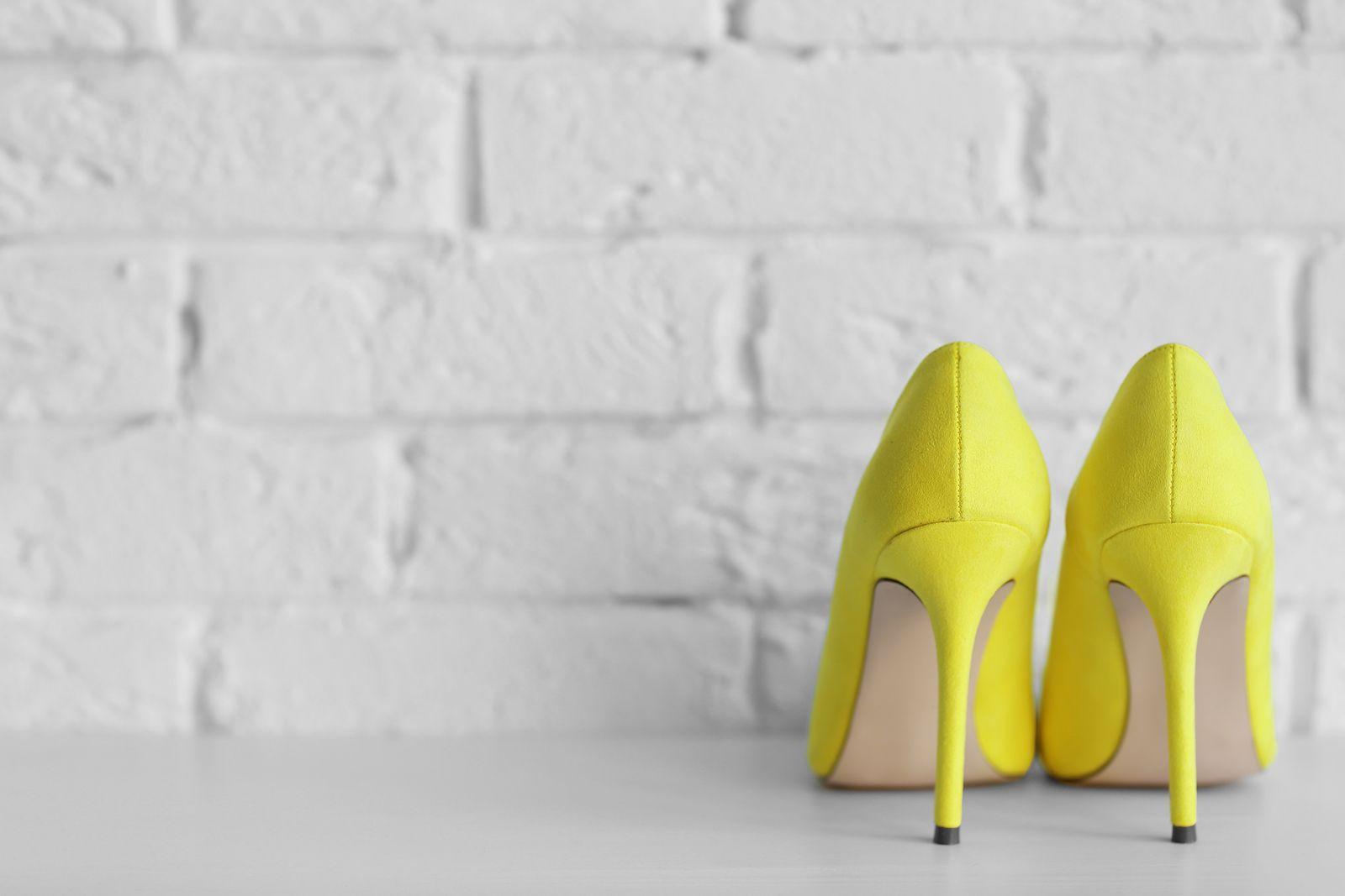 Yellow woman high heels on a brick wall background
