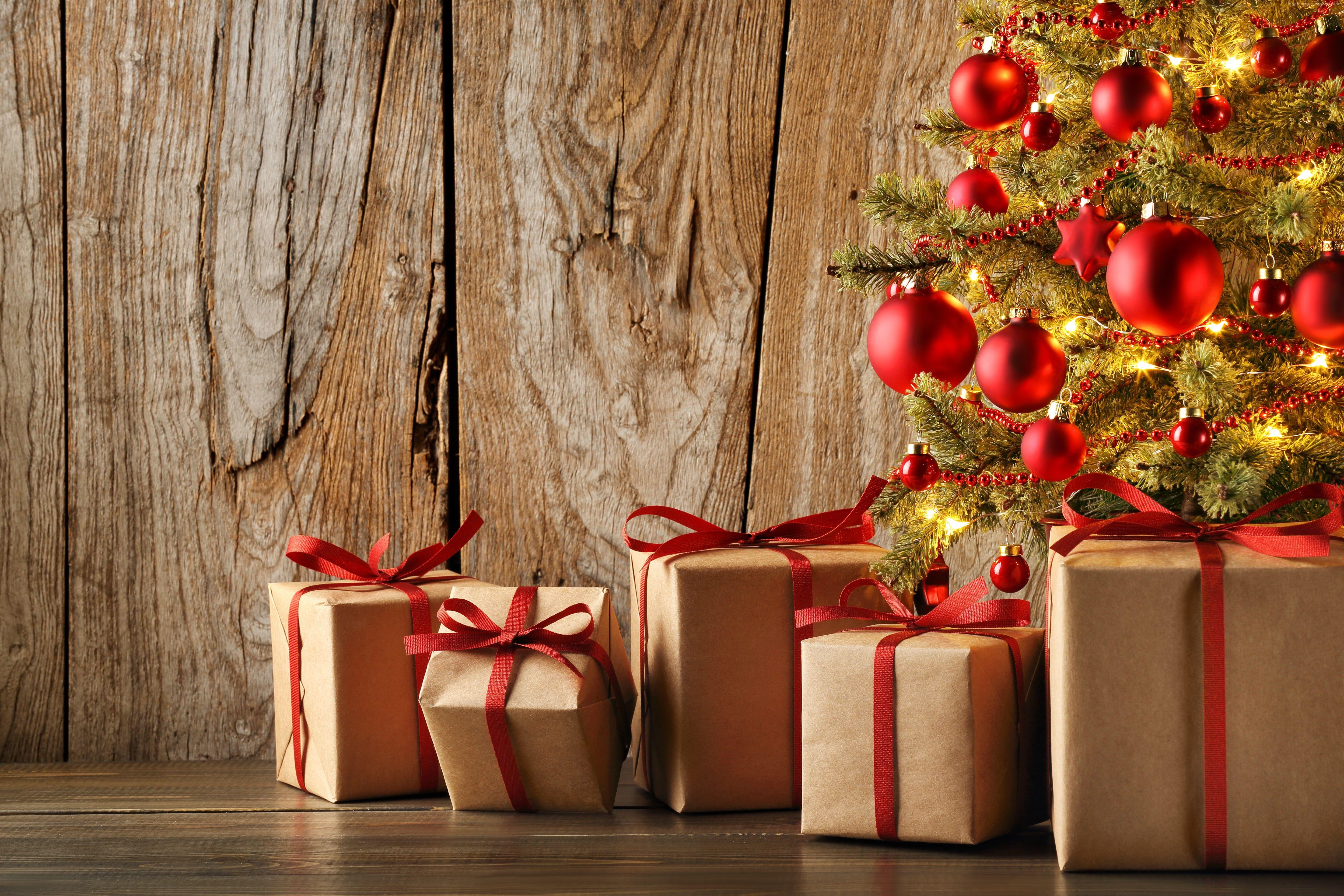 Five brown gift box beside Christmas tree HD wallpaper