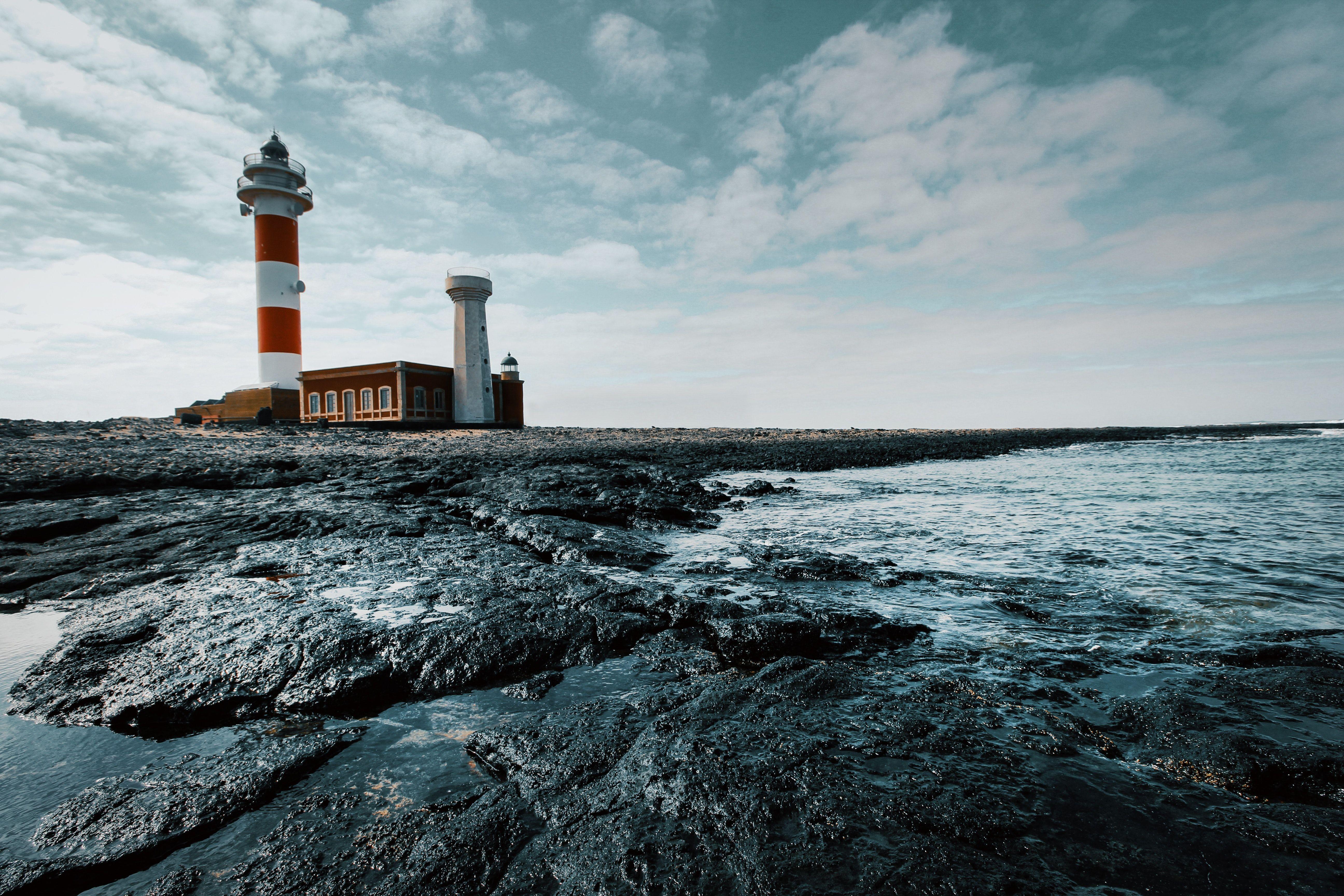 Red and White Lighthouse on Land · Free