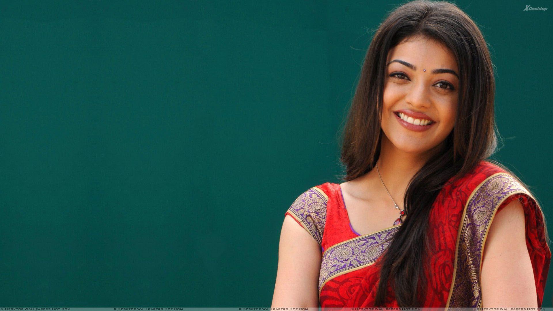 Kajal Aggarwal Cute Smiling Face In Red Saree And Long Hairs Wallpaper