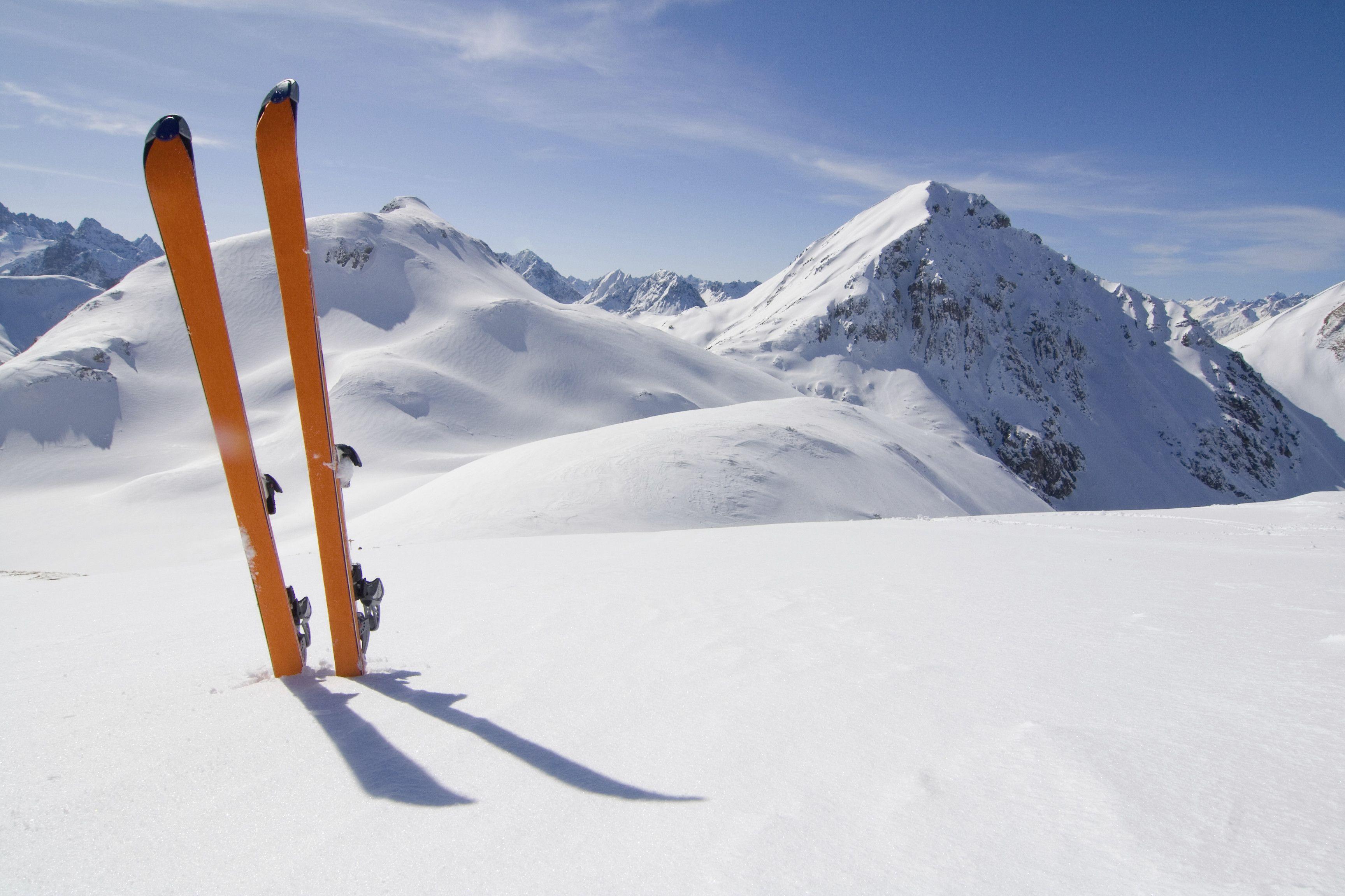 Orange skis in the snow landscape. Various sports