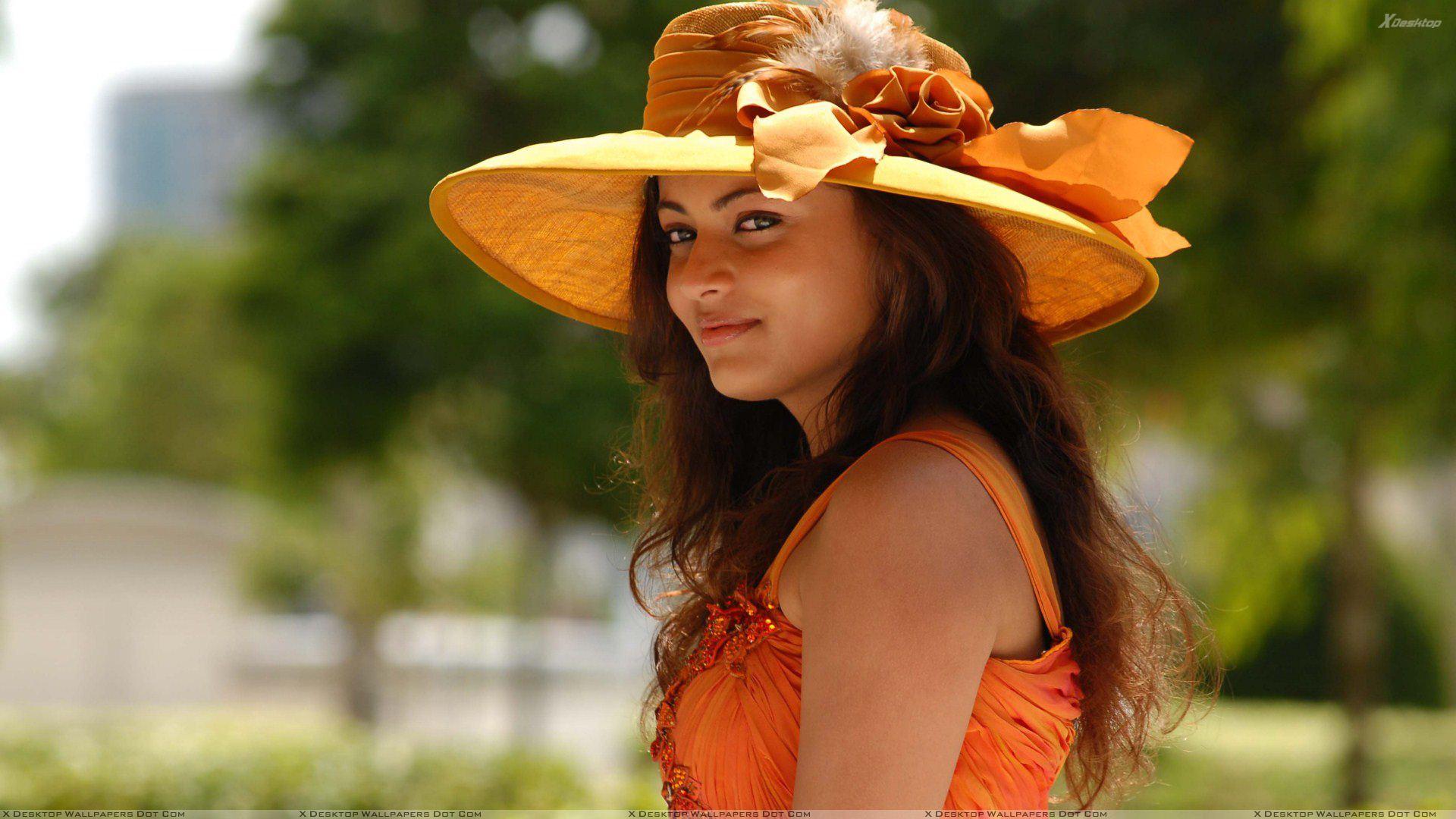 Sneha Ullal In Orange Dress N Orange Hat Side Pose