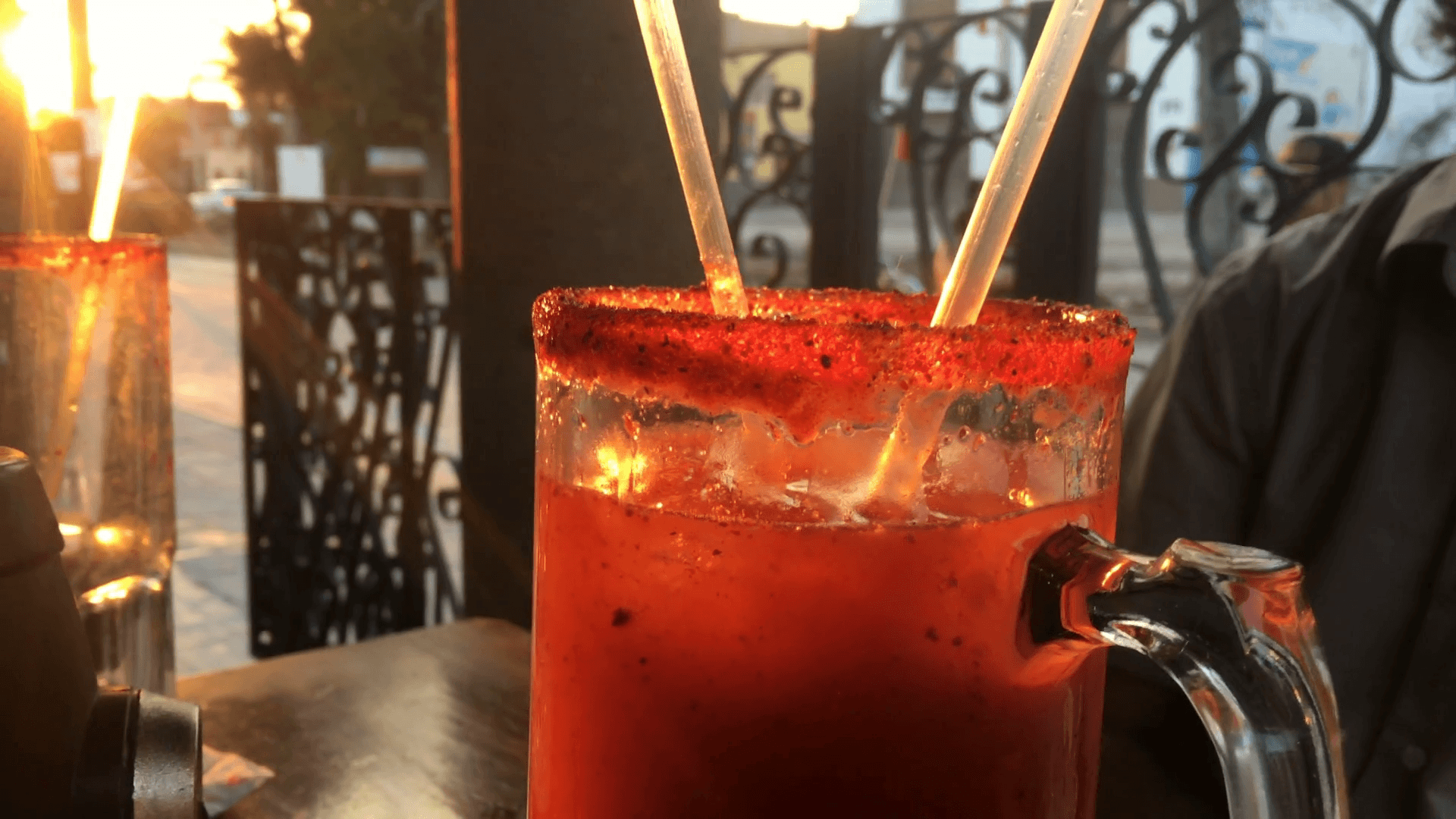 Close up of a michelada or bloody mary cocktail at an outdoor cafe