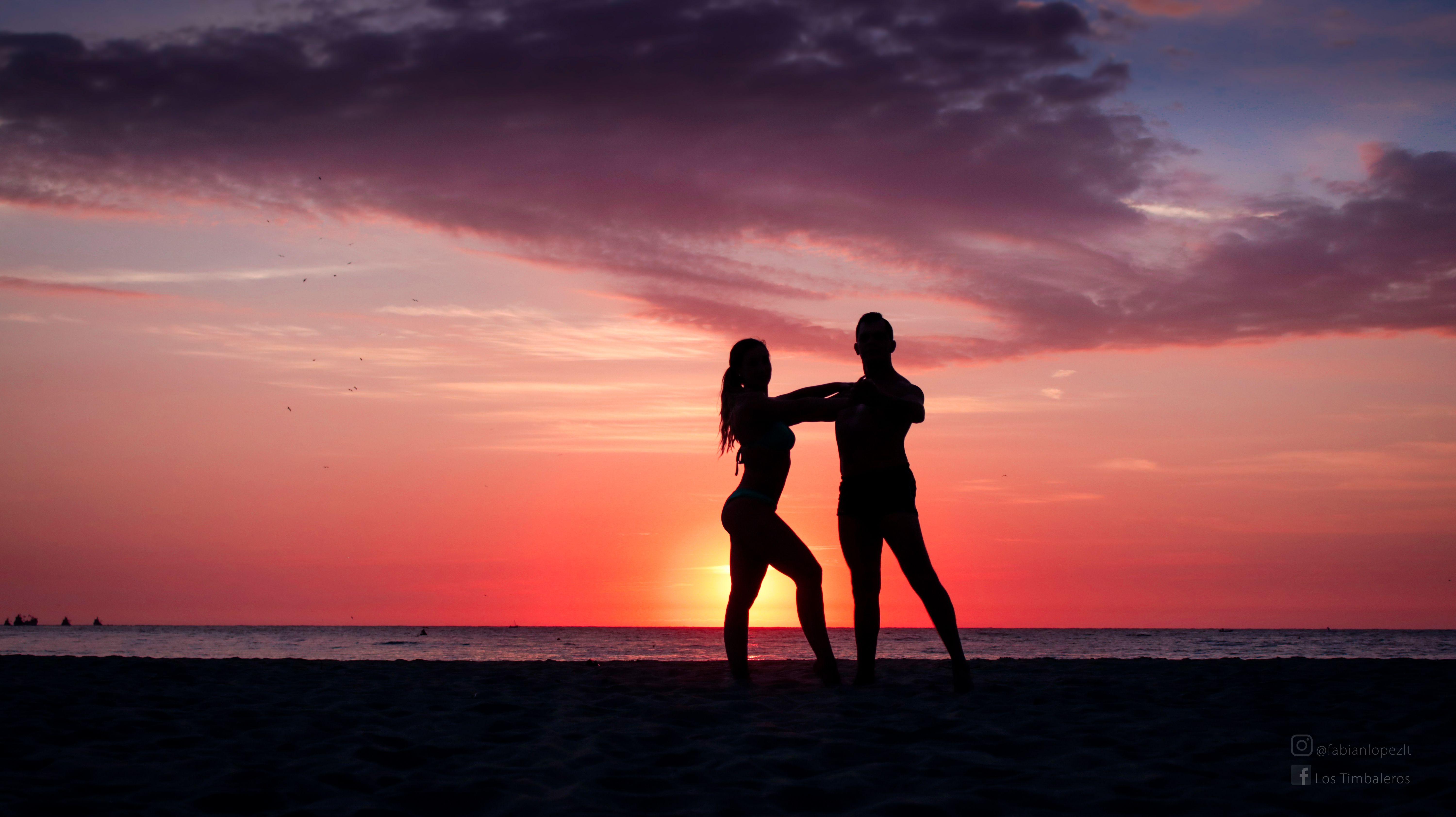 Pareja bailando en la playa al atardecer silueta sombra- couple