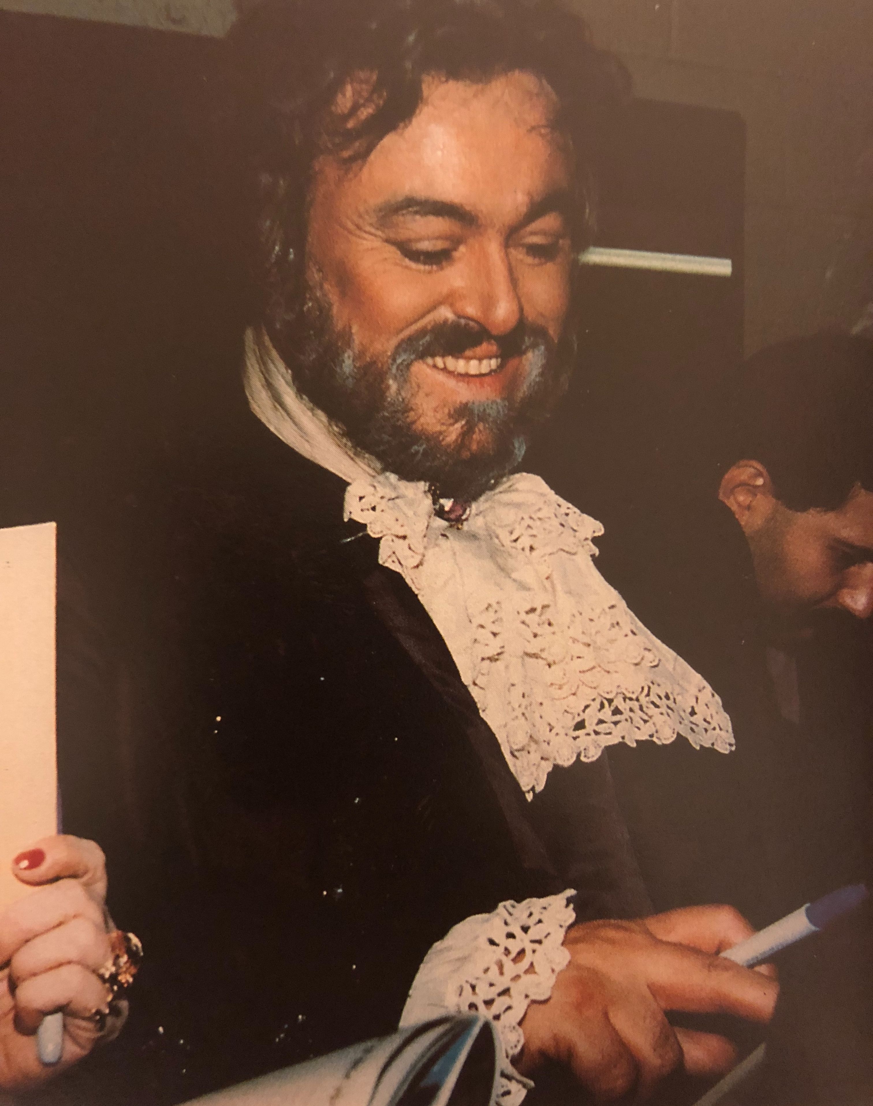 Luciano Pavarotti signs autographs backstage after a performance