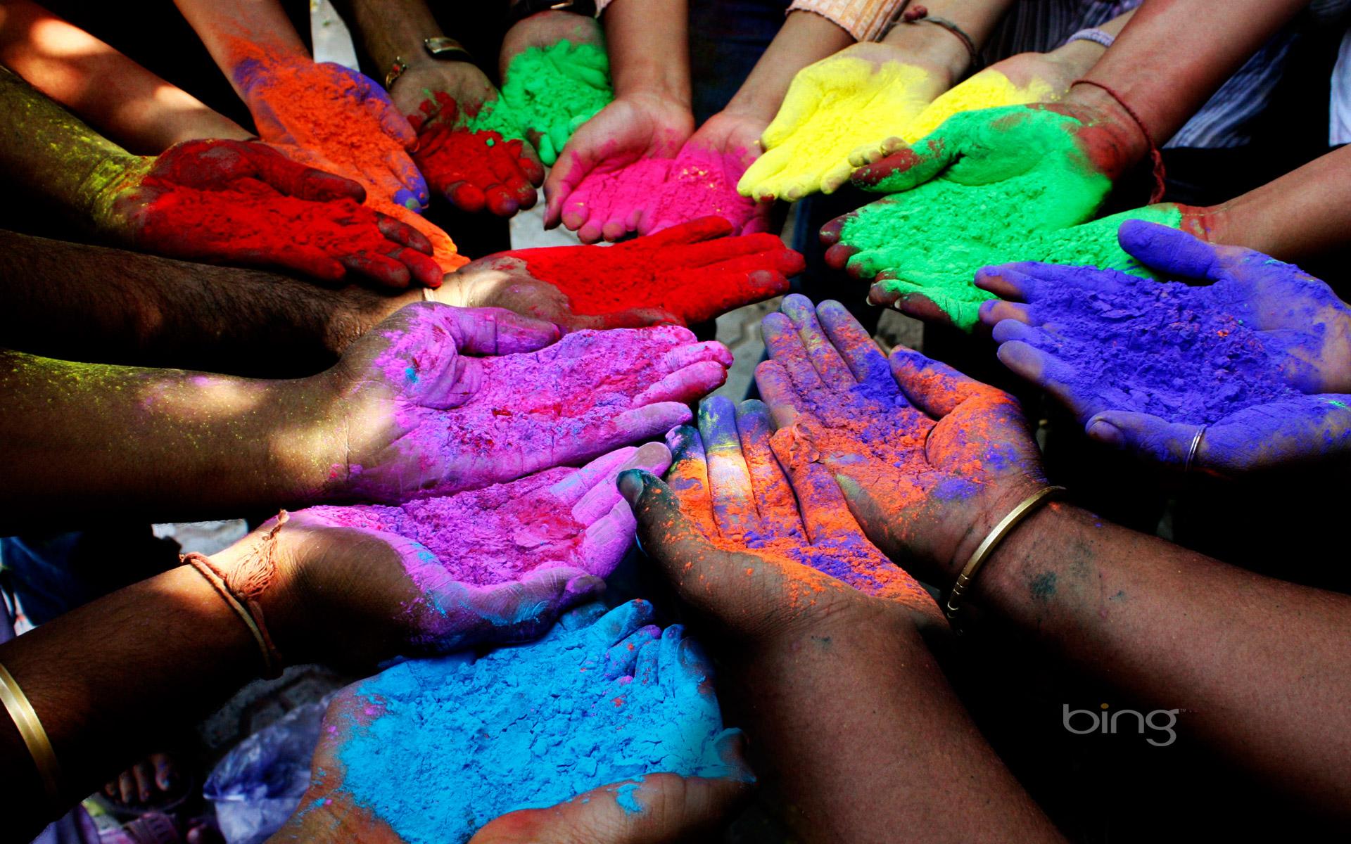 People holding colored powders to celebrate Holi Festival of Colors