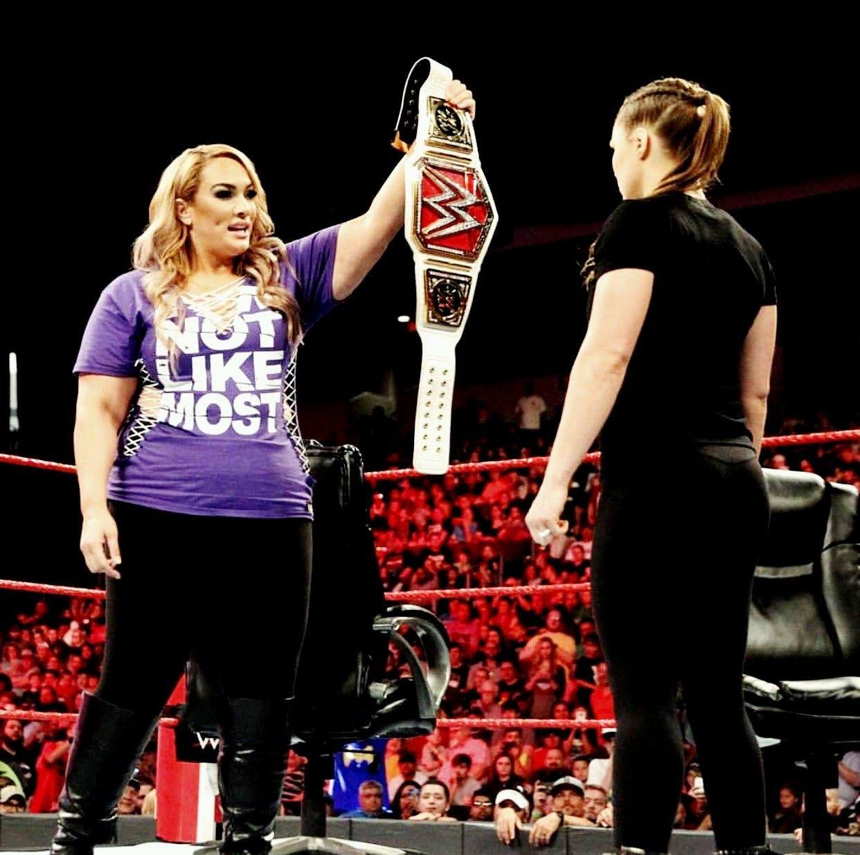 Raw Woman Champion Nia Jax holding up the belt against Ronda Rousey