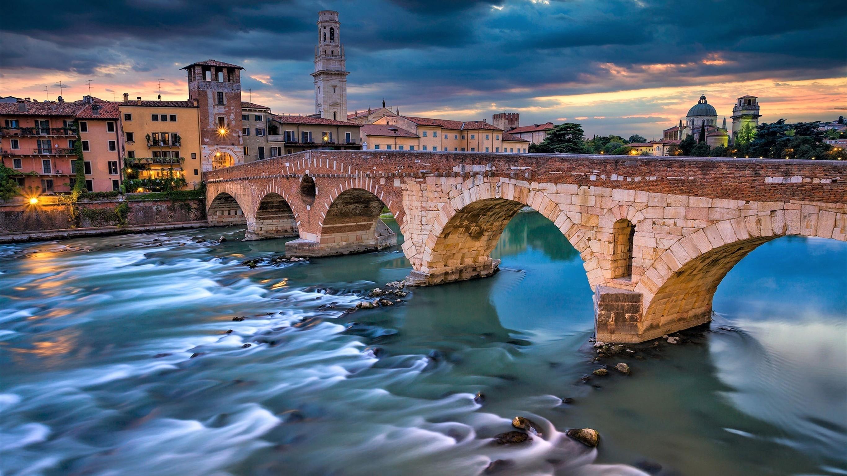 Download 2732x1536 Italy, Verona, Bridge, Dark Clouds, Buildings