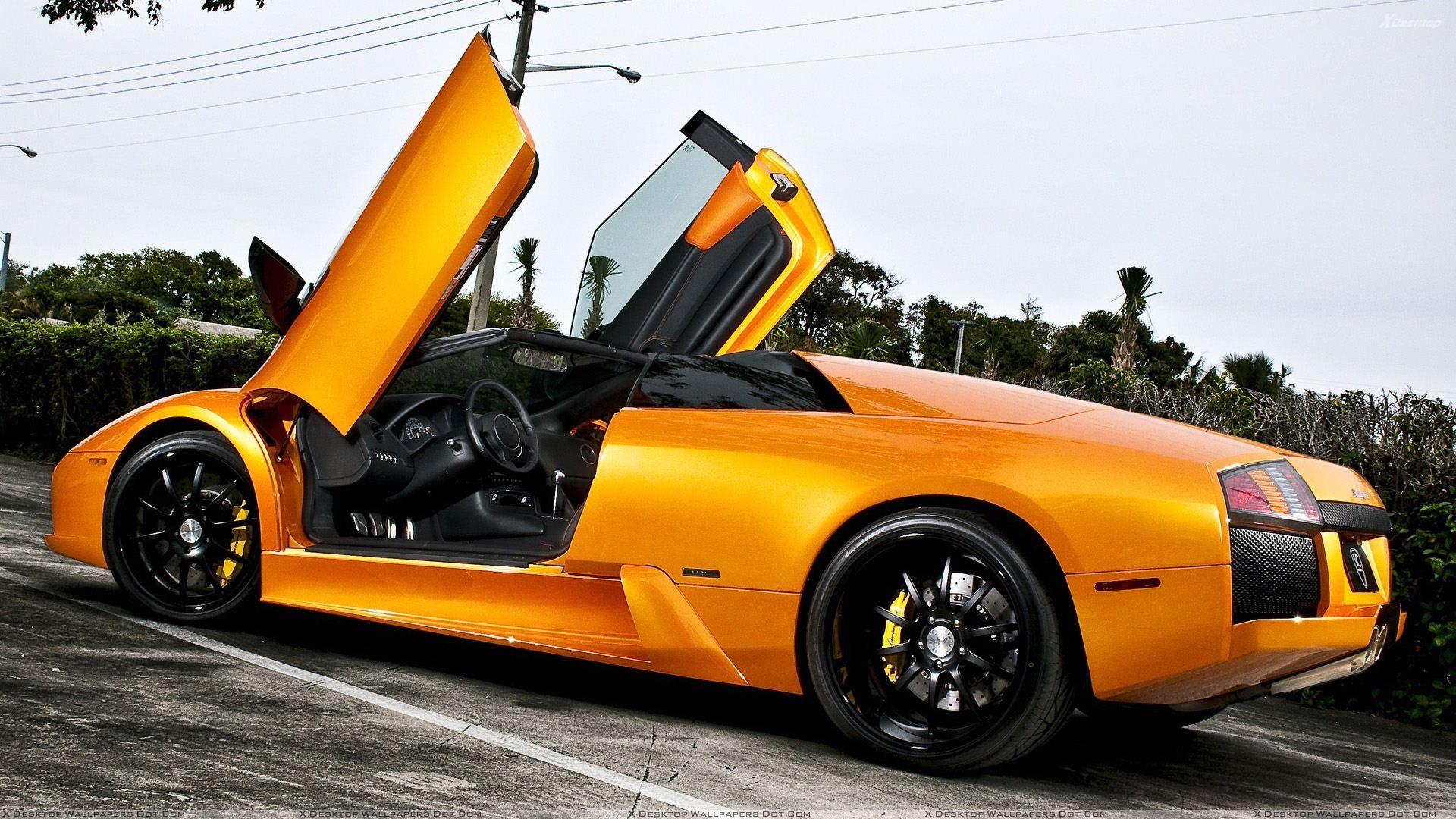 Lamborghini Murcielago In Orange Doors Open Side Pose Wallpaper