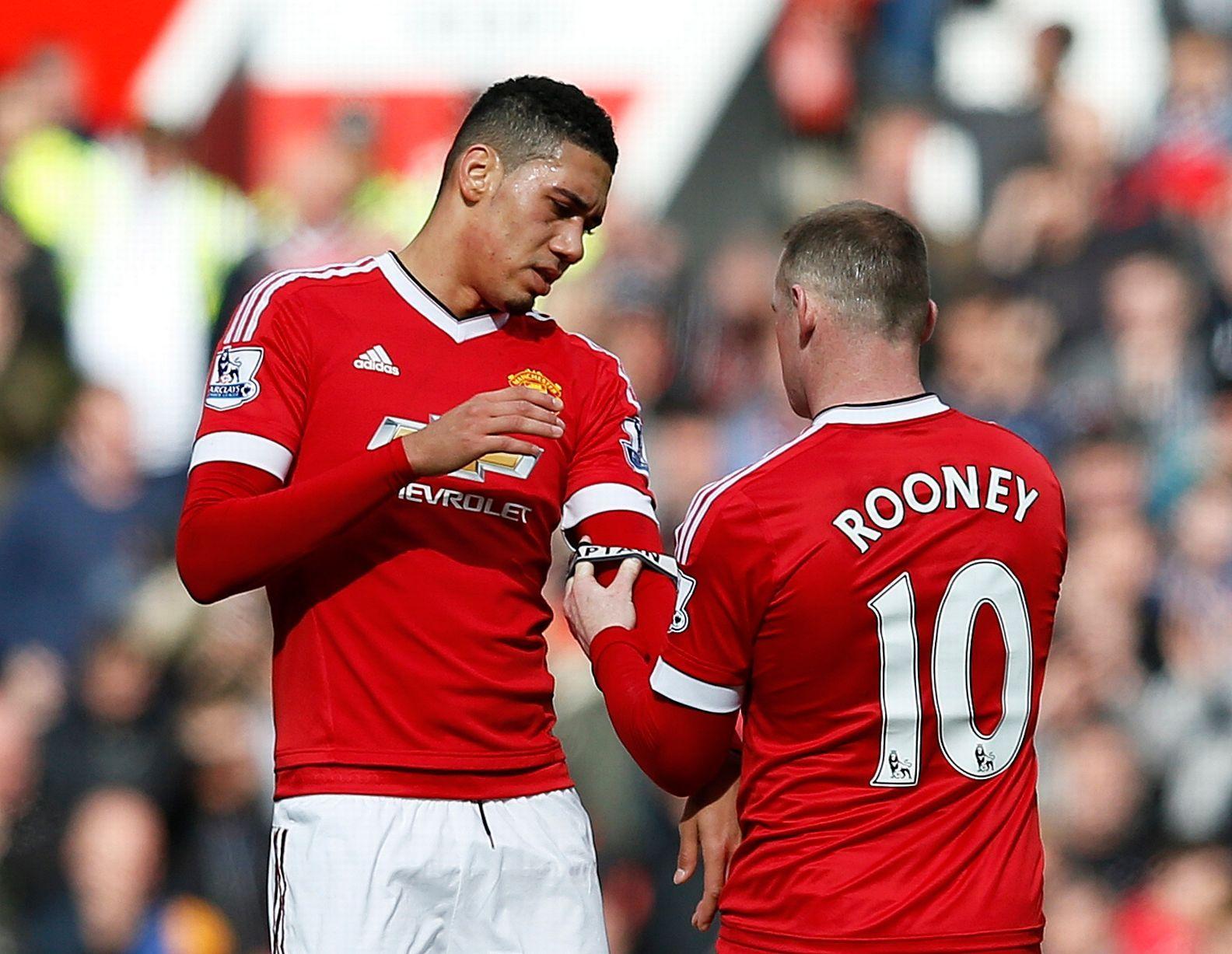 Wayne Rooney hands the captains armband to Chris Smalling as he is