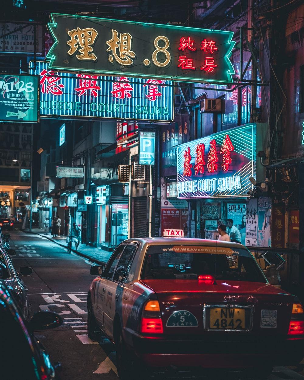 Taxi in a neon lit street. HD photo