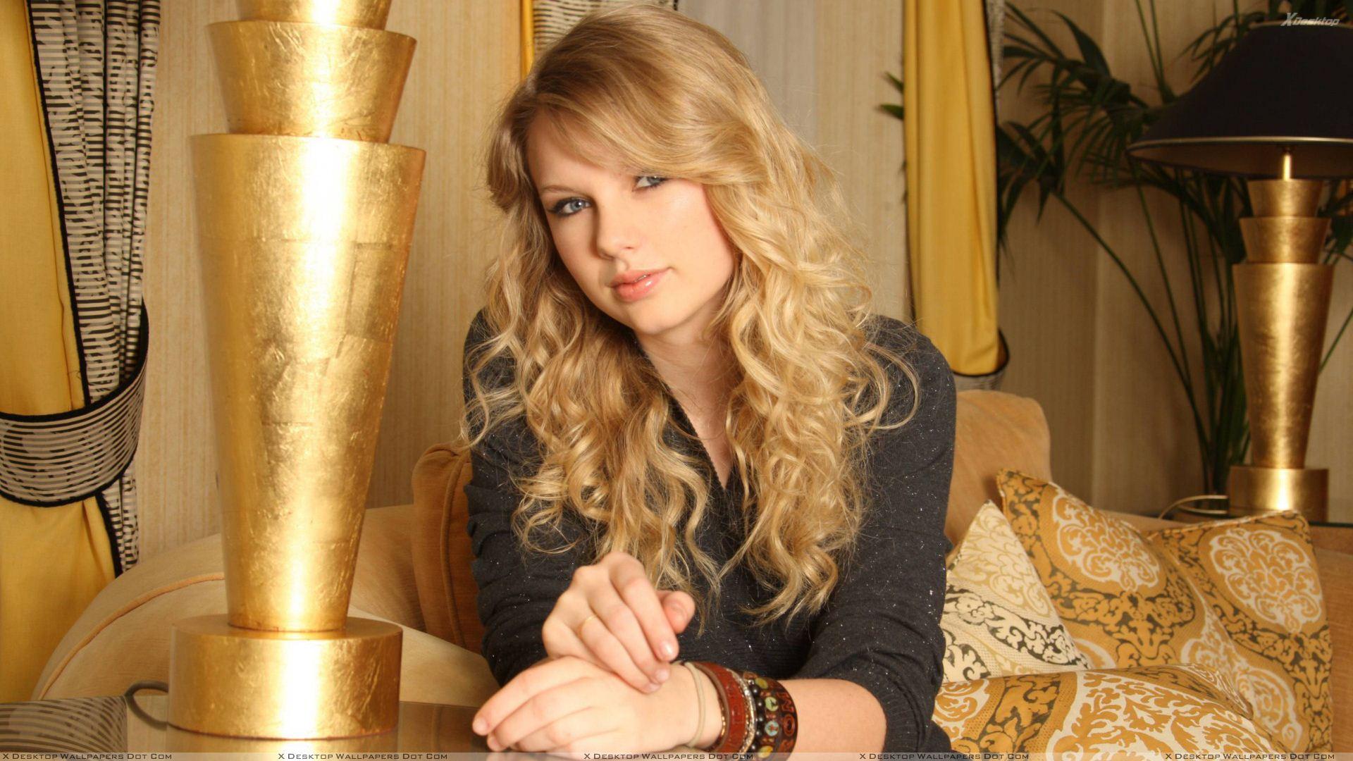 Taylor Swift Sitting In Black Dress Looking Front Photohoot Wallpaper