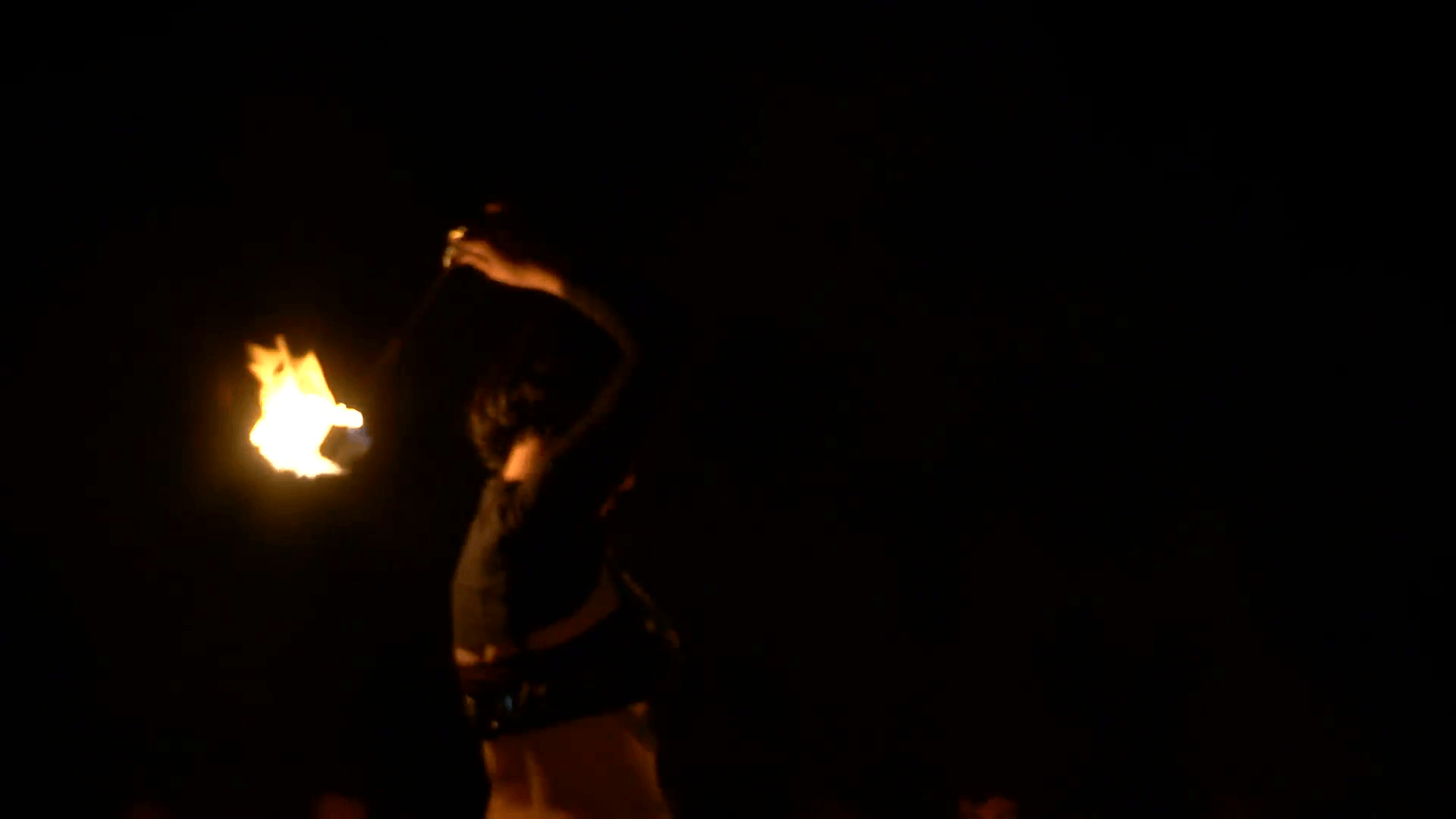 A girl dance in a fire show during the festival of Beltane the