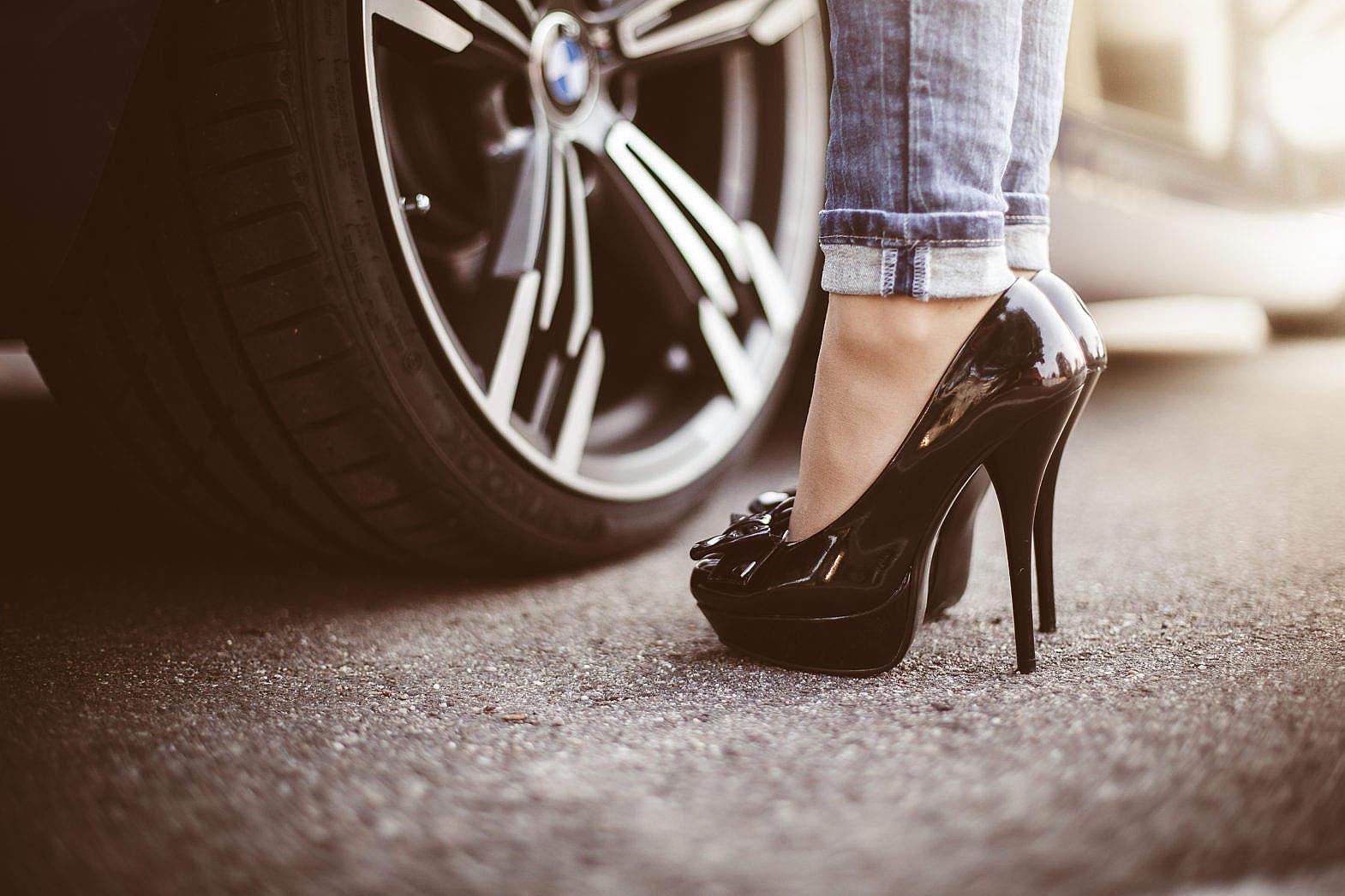 Woman in Black High Heels Standing Next to a Car Free