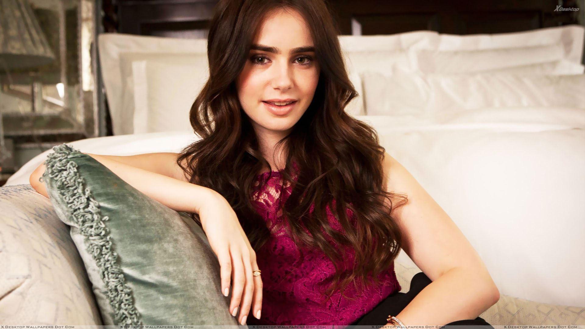 Lily Collins Sitting Pose In Pink Dress N Innocent Face Wallpaper